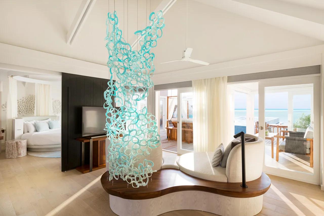 Interno della Temptation Pool Water Villa con zona salotto e vista sull'oceano al LUX* South Ari Atoll.
