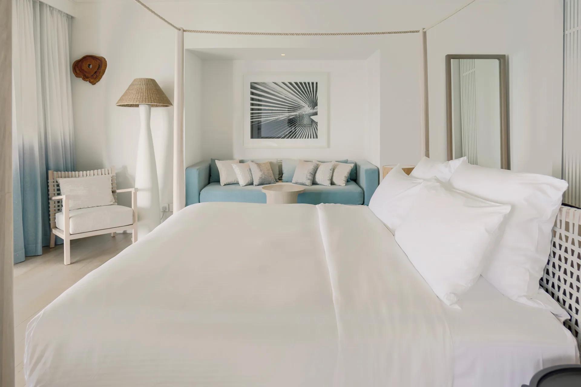 Camera Water Villa con letto matrimoniale e divano al LUX* South Ari Atoll.