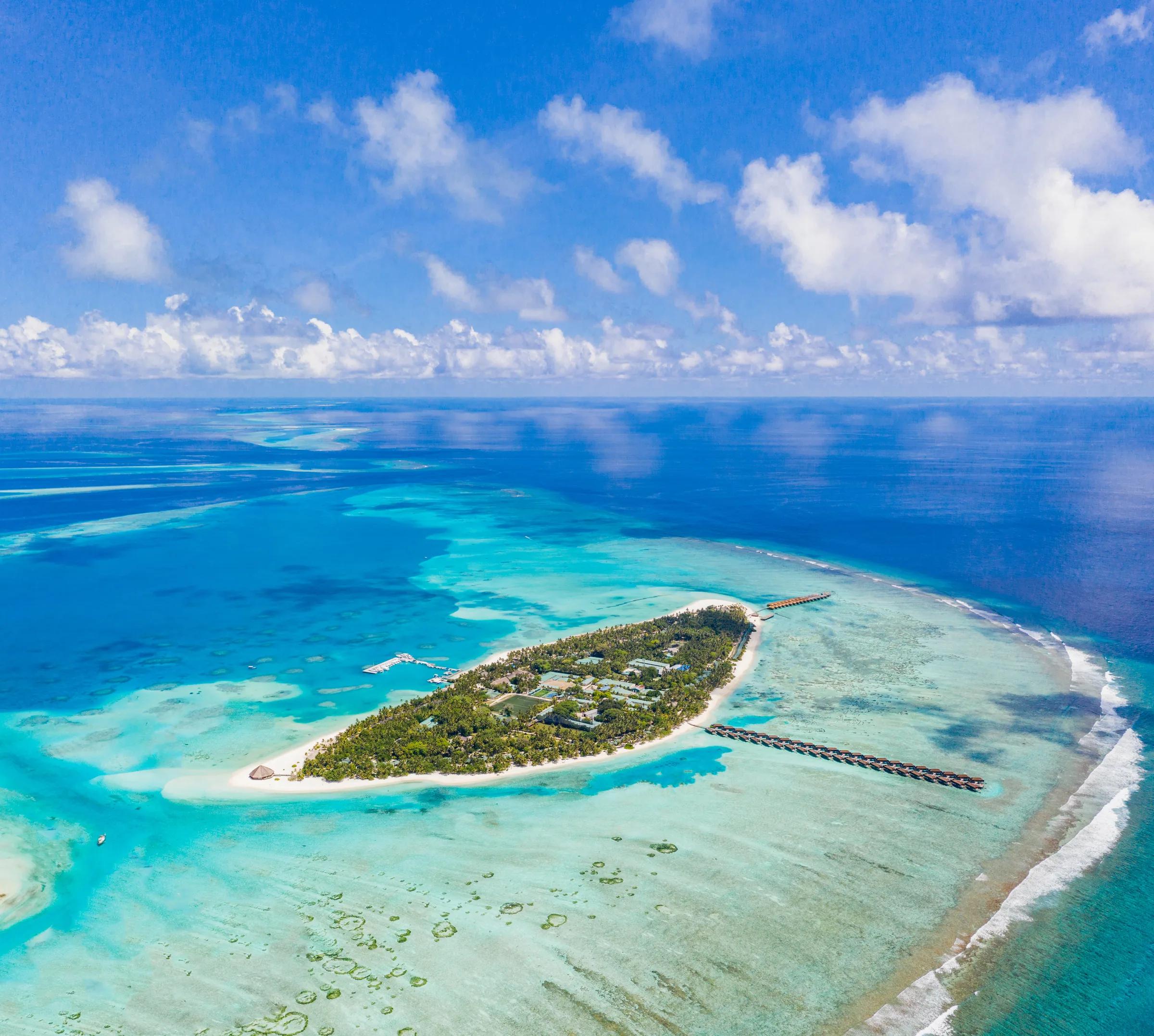Veduta aerea del Meeru Island Resort & Spa circondato da acque turchesi e barriere coralline.