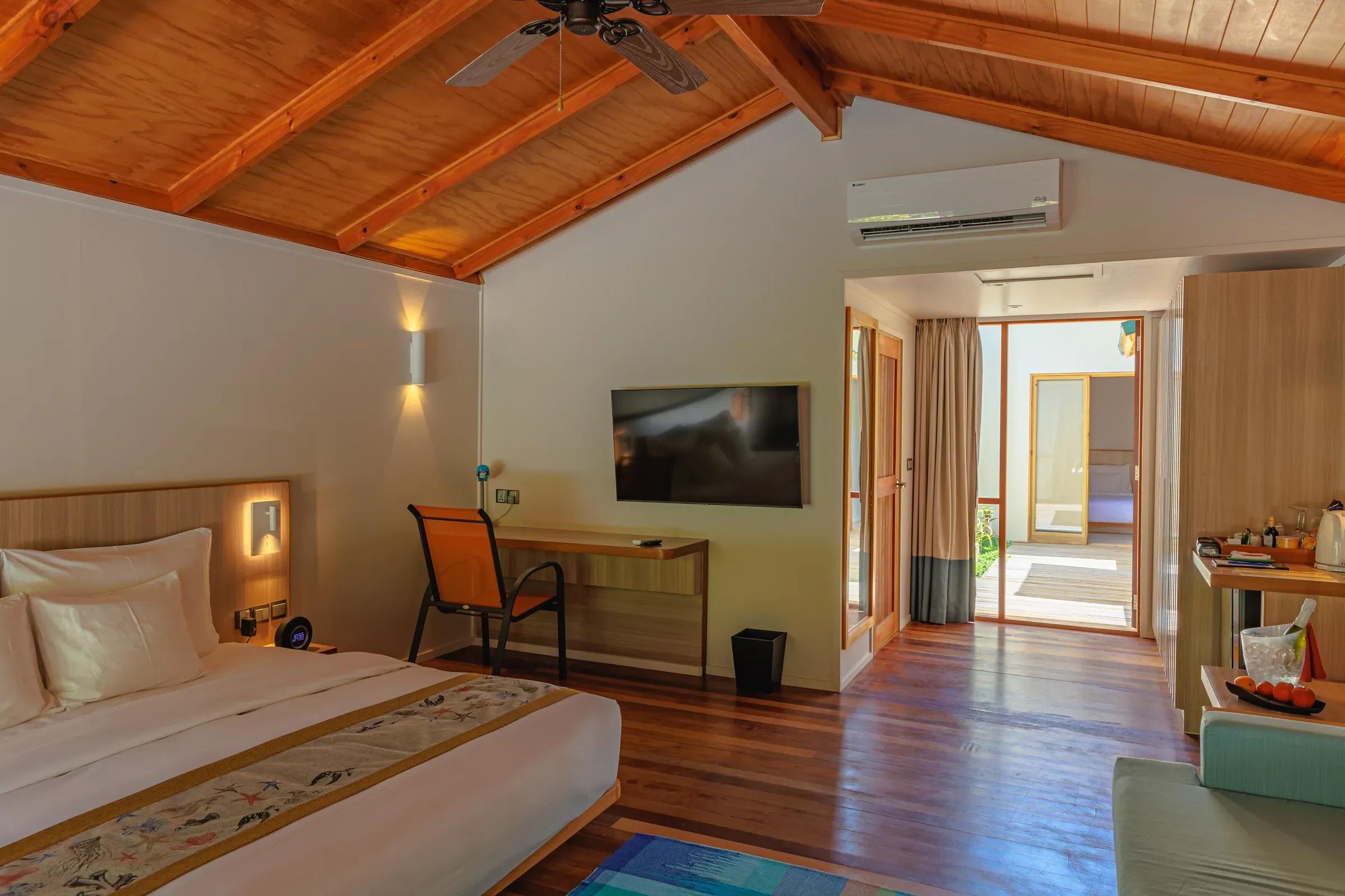 Interno della Family Villa con letto matrimoniale e TV al Meeru Island Resort & Spa.