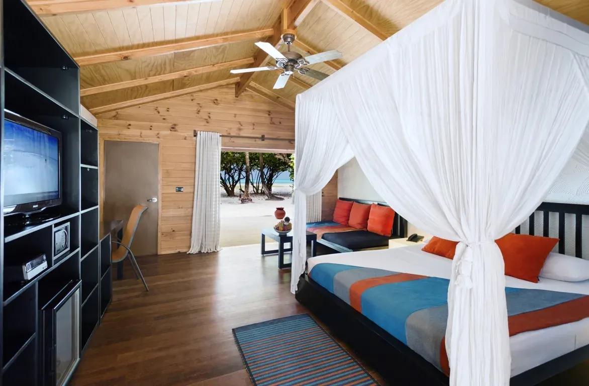 Letto matrimoniale con zanzariera e vista spiaggia dalla Jacuzzi Beach Villa del Meeru Island Resort & Spa