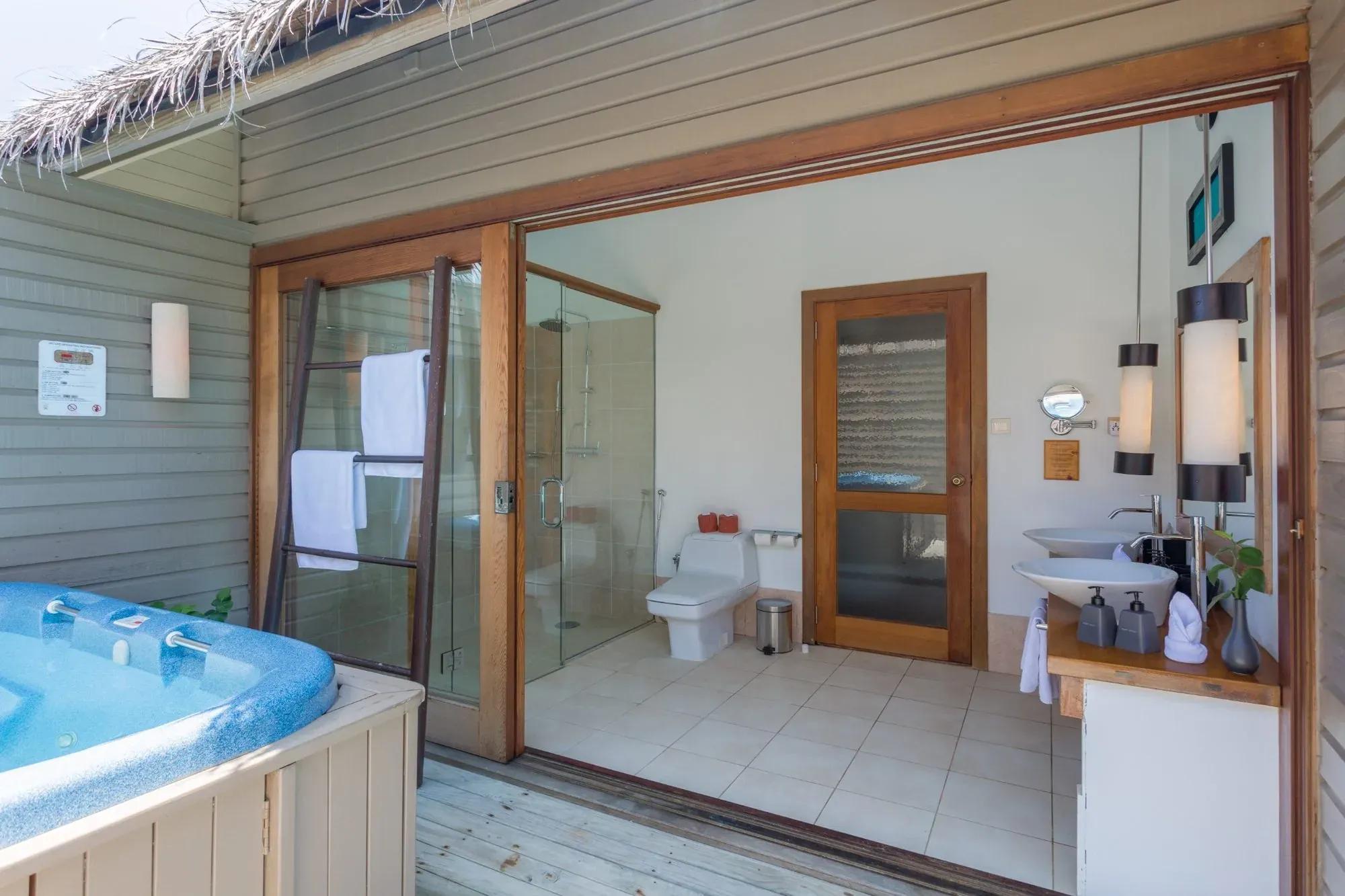 Bagno della Ocean Villa con pavimento piastrellato e vasca idromassaggio al Meeru Island Resort & Spa.