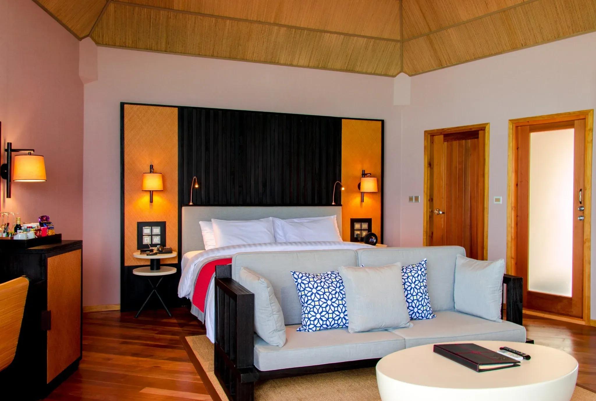 Interno della Water Front Villa con letto matrimoniale e divano al Meeru Island Resort & Spa