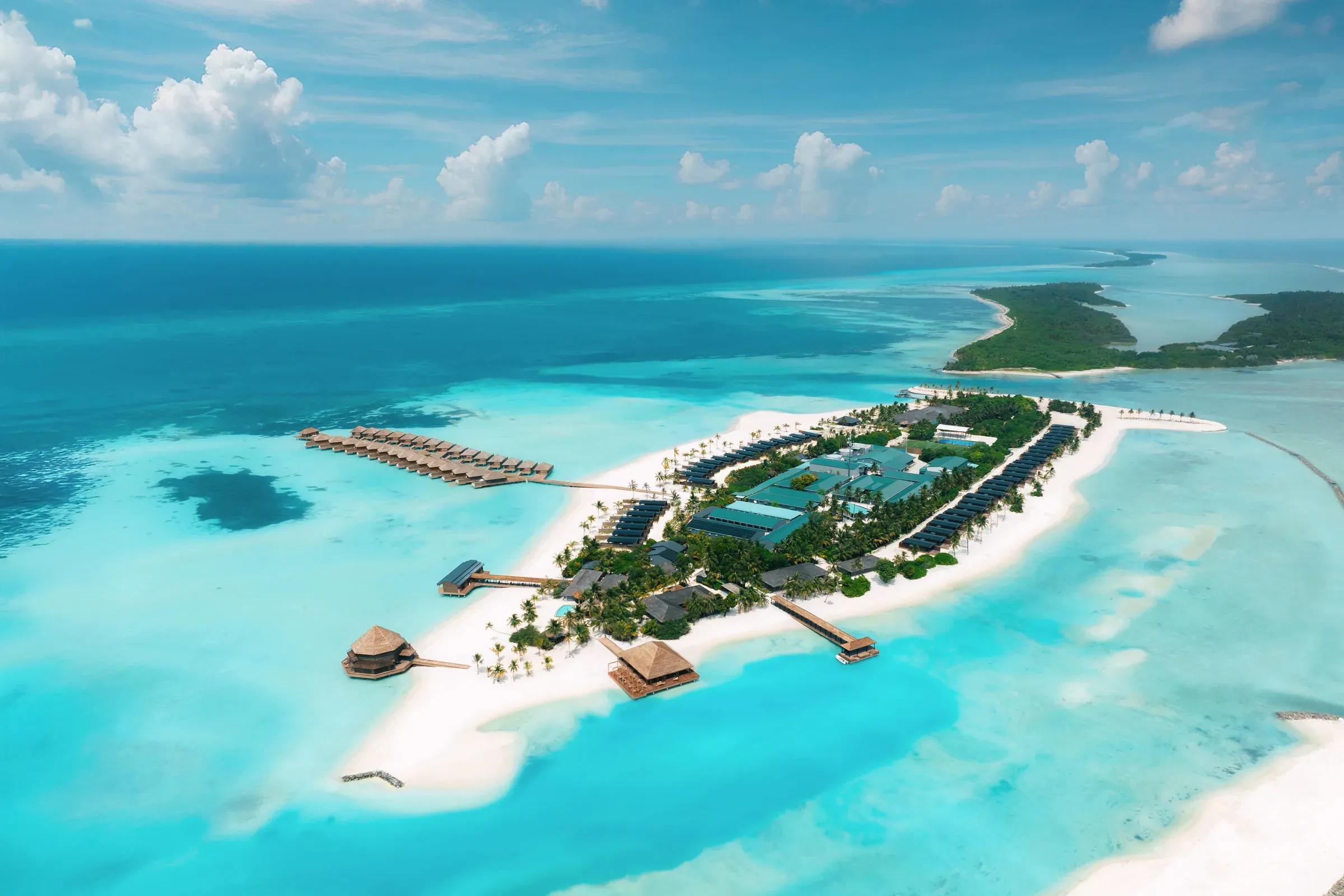 Vista aerea dell'isola del Nala Maldives By Jawakara con ville sull'acqua e spiagge bianche circondate da laguna turchese.