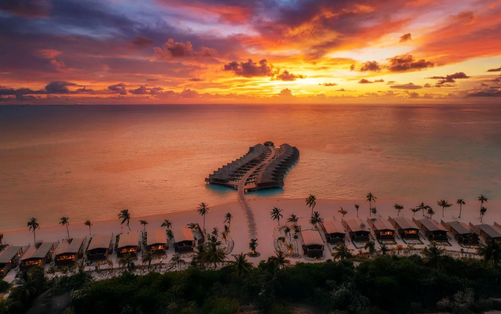 Veduta aerea di bungalow sull'acqua al tramonto al Nala Maldives By Jawakara