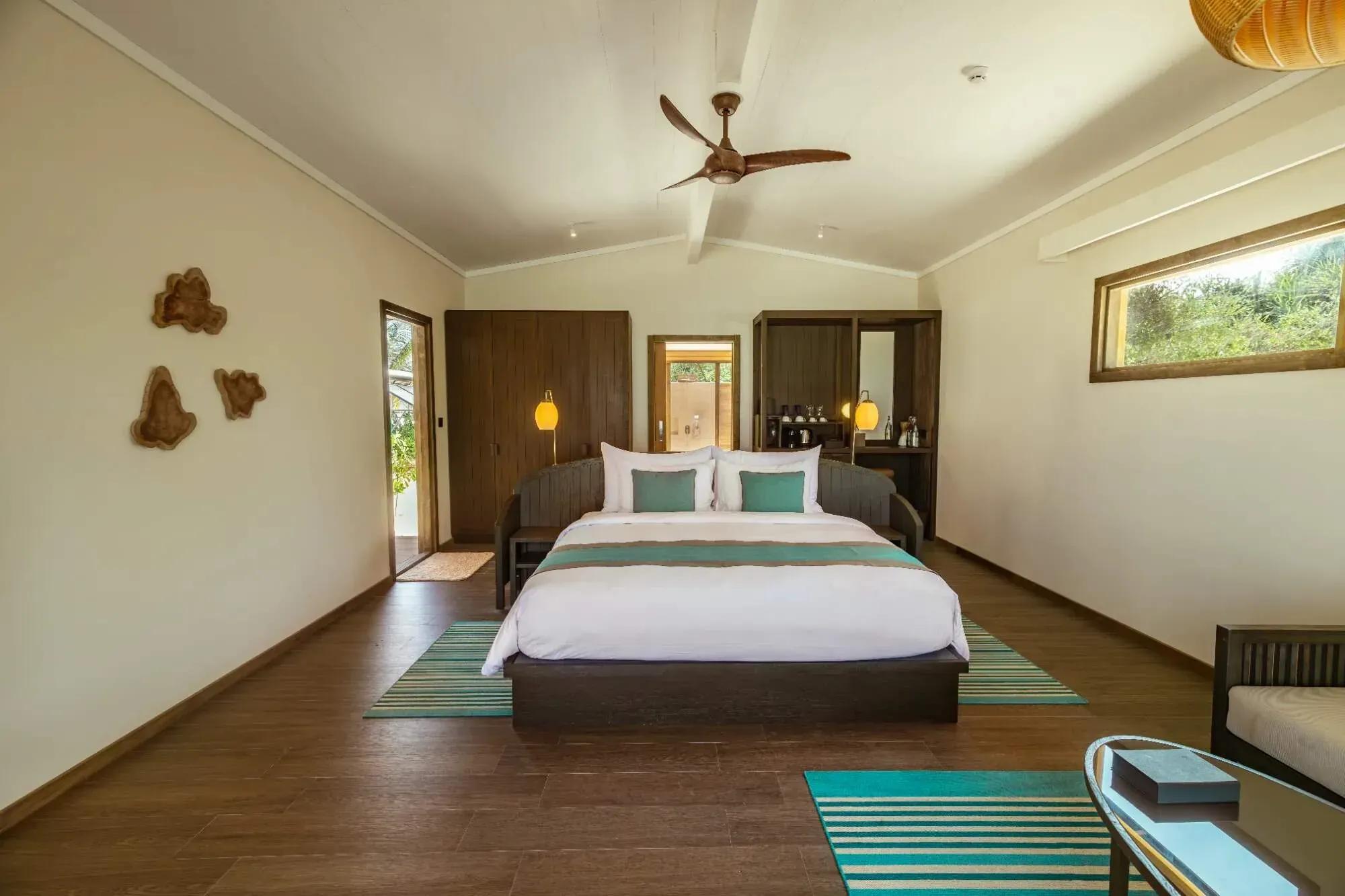 Camera da letto della Sunset Beach Pool Villa con letto matrimoniale e finestre al Nala Maldives By Jawakara.