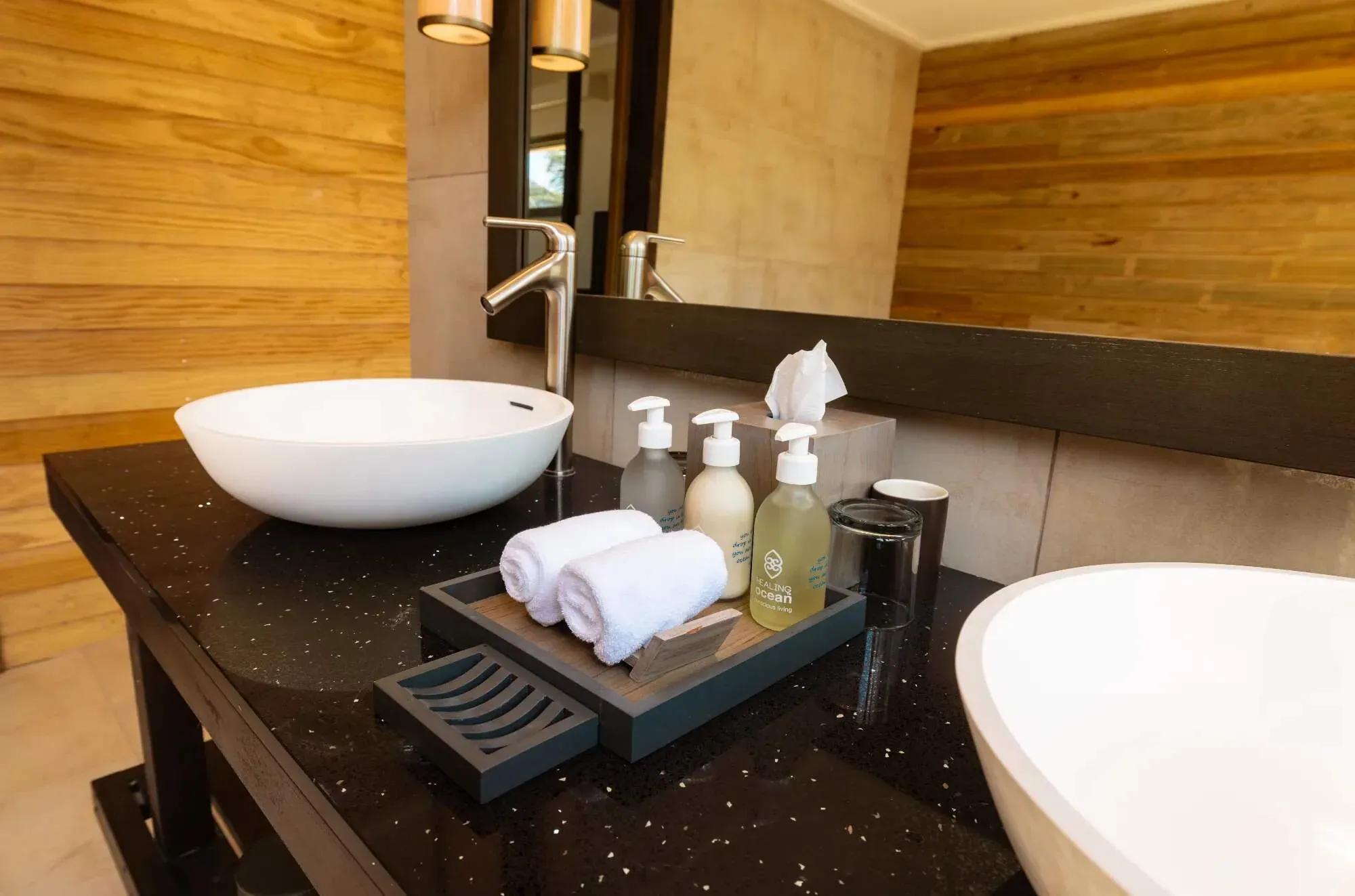 Lavabo moderno con accessori da bagno e parete in legno nella Sunset Beach Pool Villa del Nala Maldives By Jawakara.