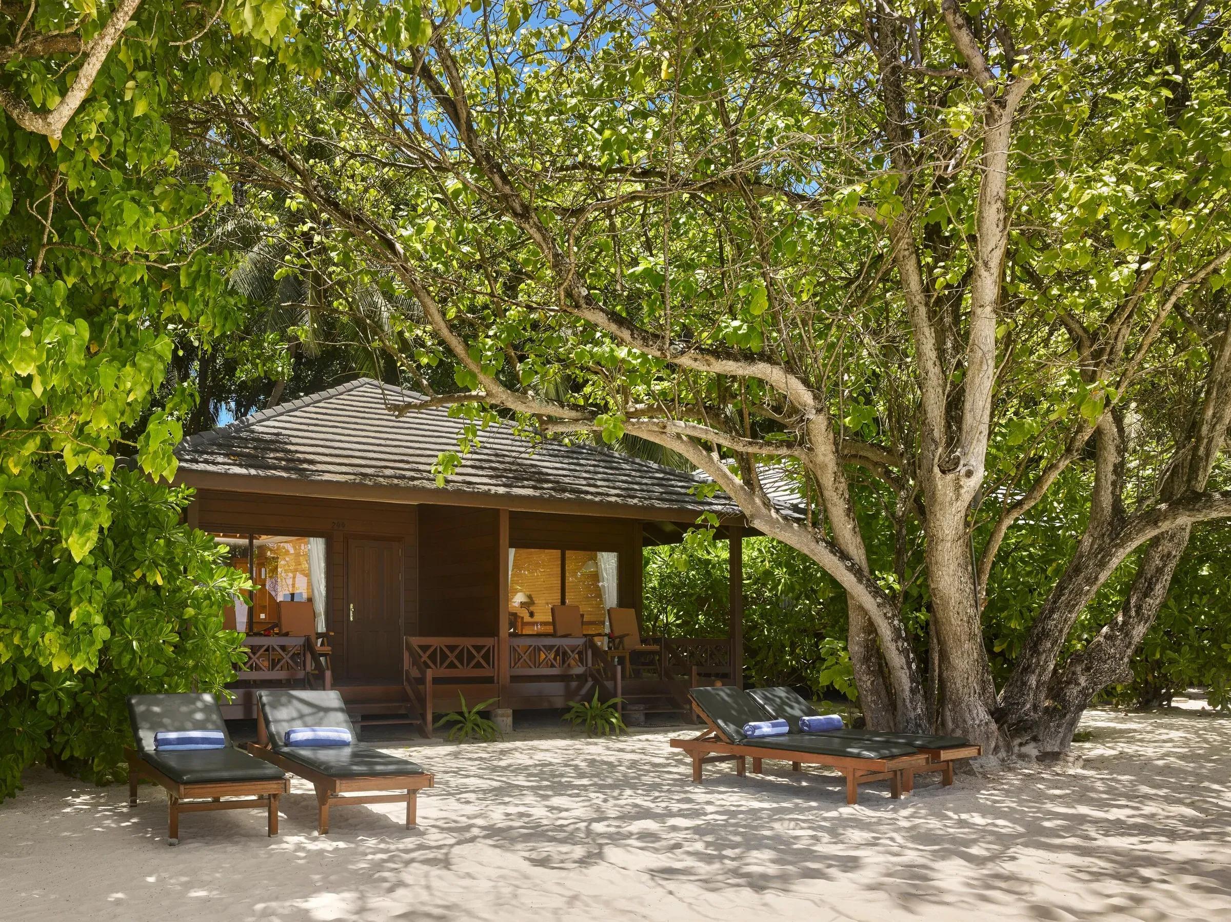 Sunset Beach Villa con lettini prendisole e terrazza coperta circondata da vegetazione tropicale al Royal Island Resort & Spa