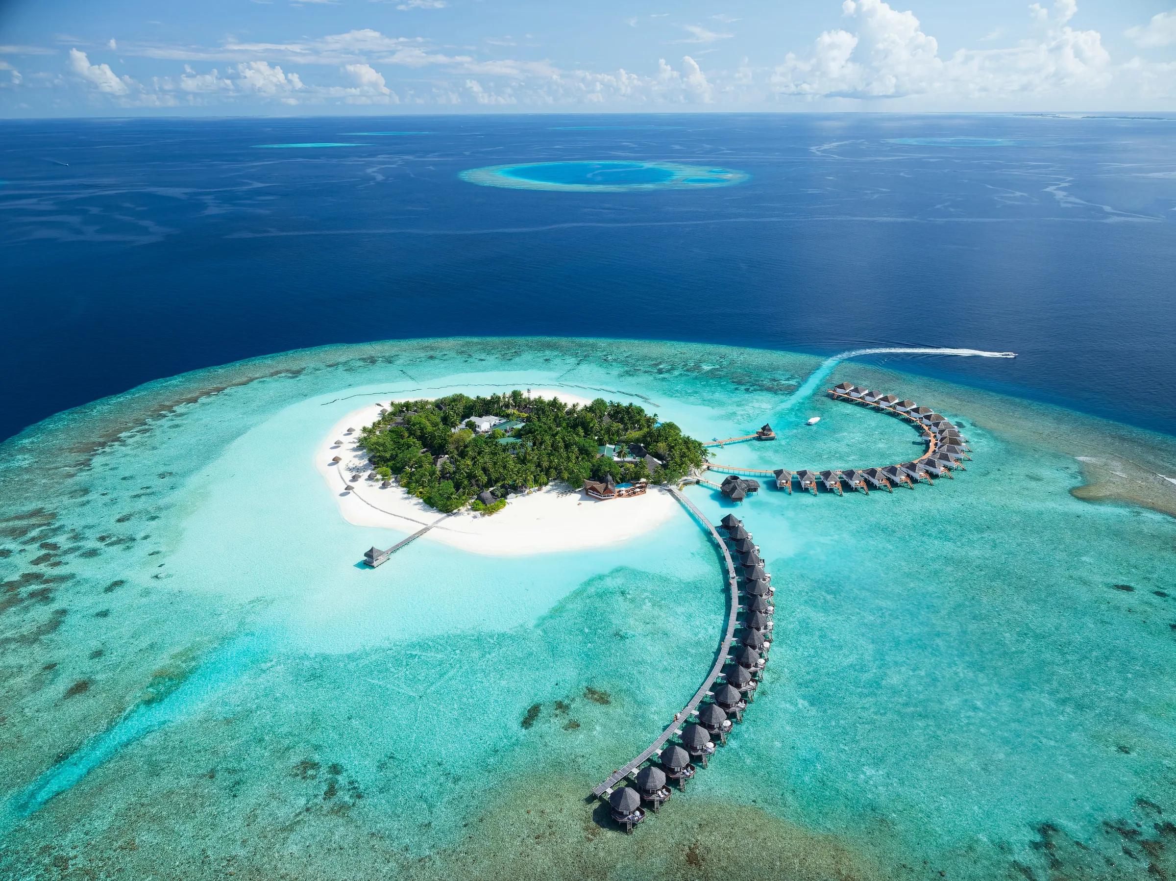 Veduta aerea di bungalow sull'acqua e spiaggia al Thulhagiri Island Resort & Spa.