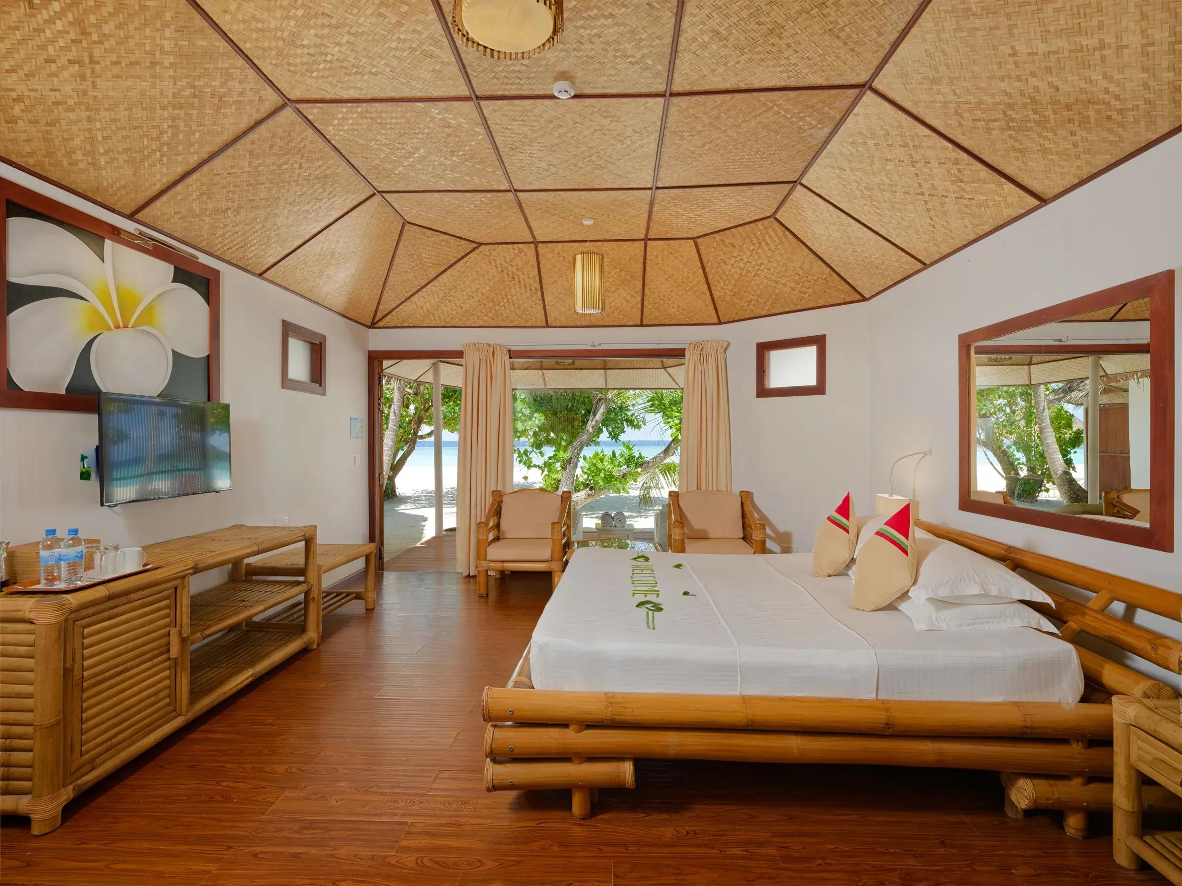 Interno della Beach Bungalow con letto matrimoniale e accesso alla spiaggia del Thulhagiri Island Resort & Spa.