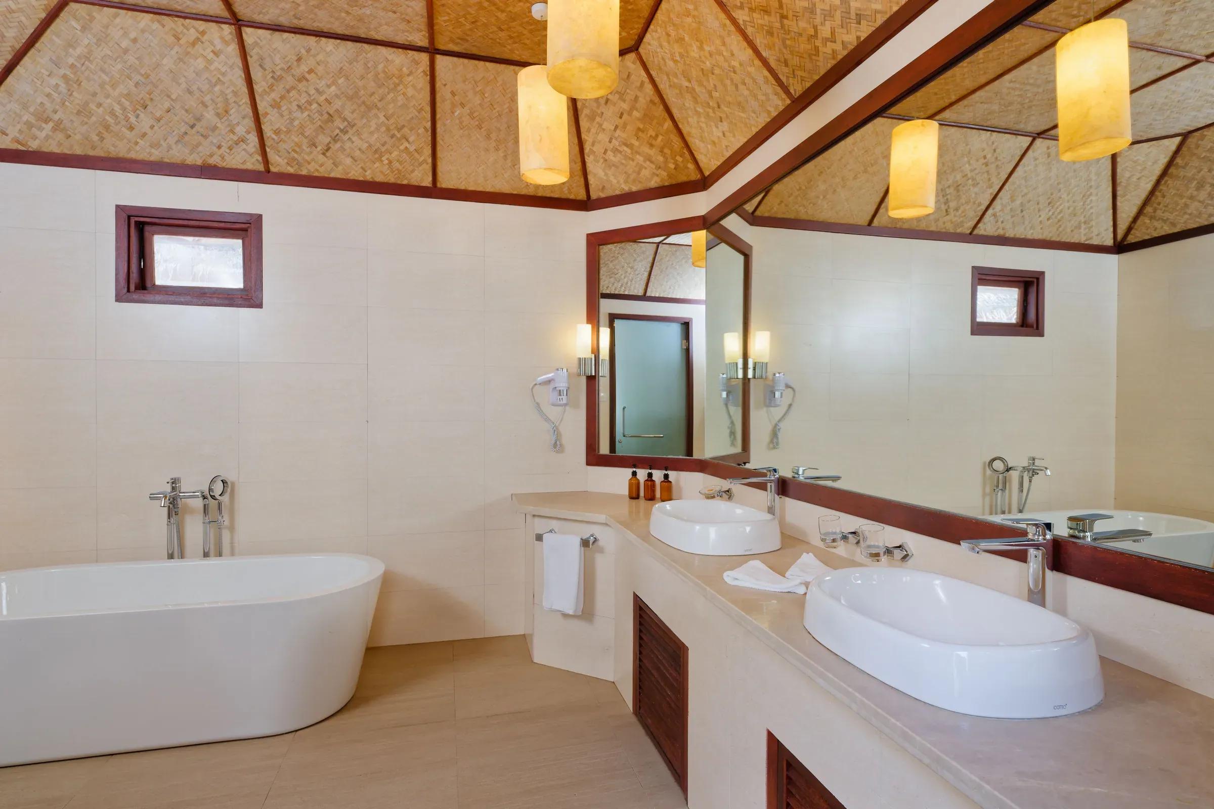 Interno del bagno con vasca e doppi lavabi nella Beach Bungalow del Thulhagiri Island Resort & Spa.
