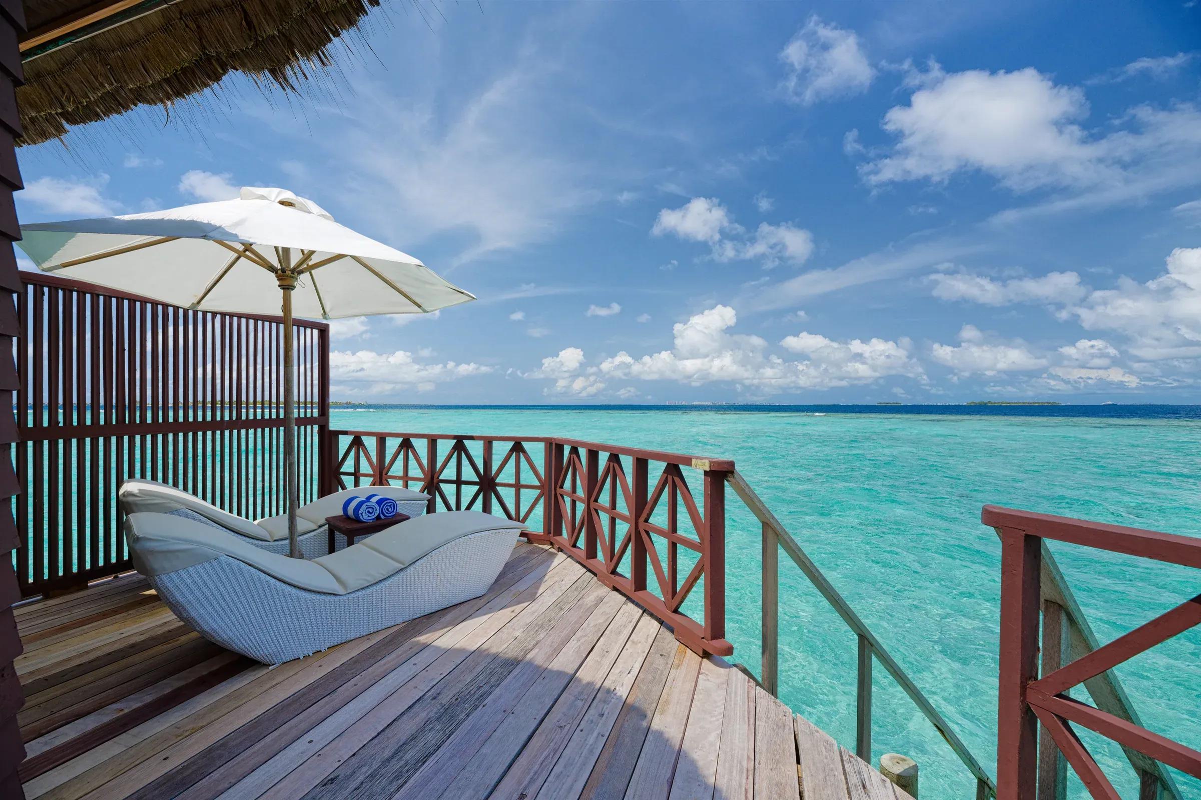 Terrazza della Water Bungalow con lettino e vista mare al Thulhagiri Island Resort & Spa.