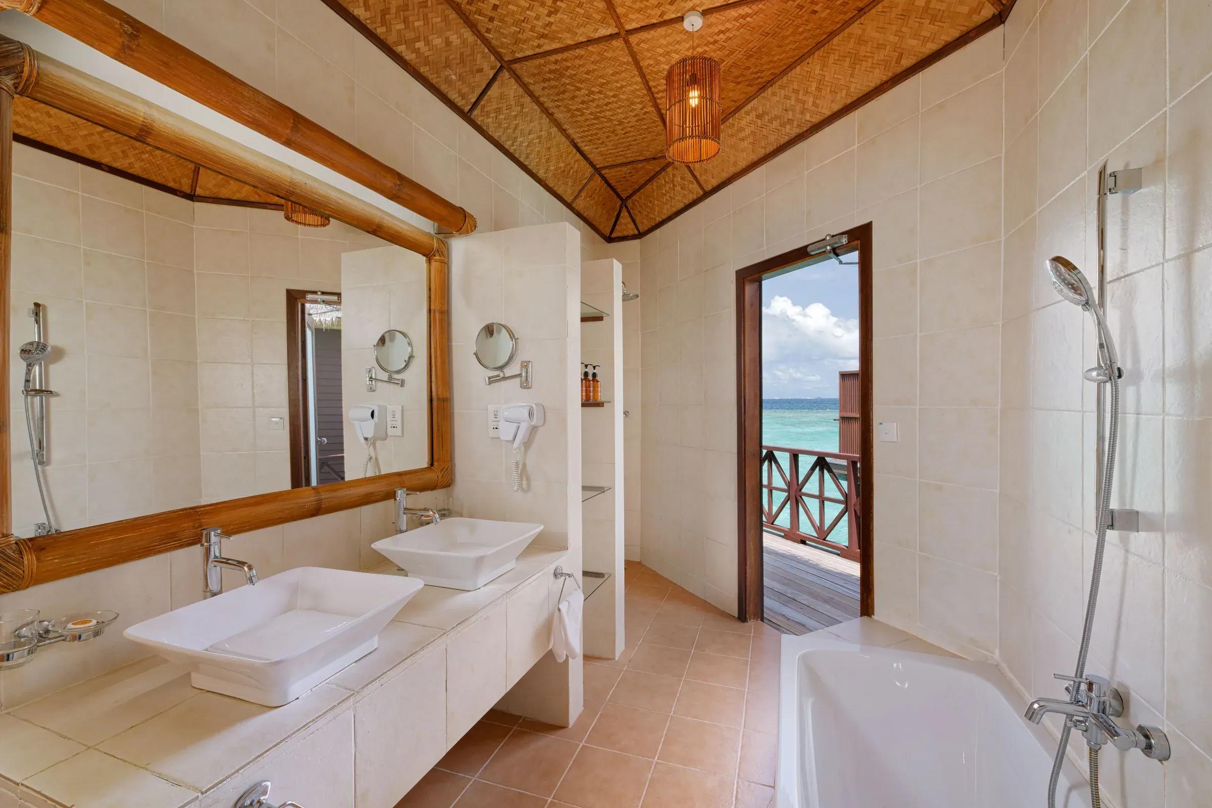 Interno del bagno nella Water Bungalow con vista sull'oceano al Thulhagiri Island Resort & Spa.