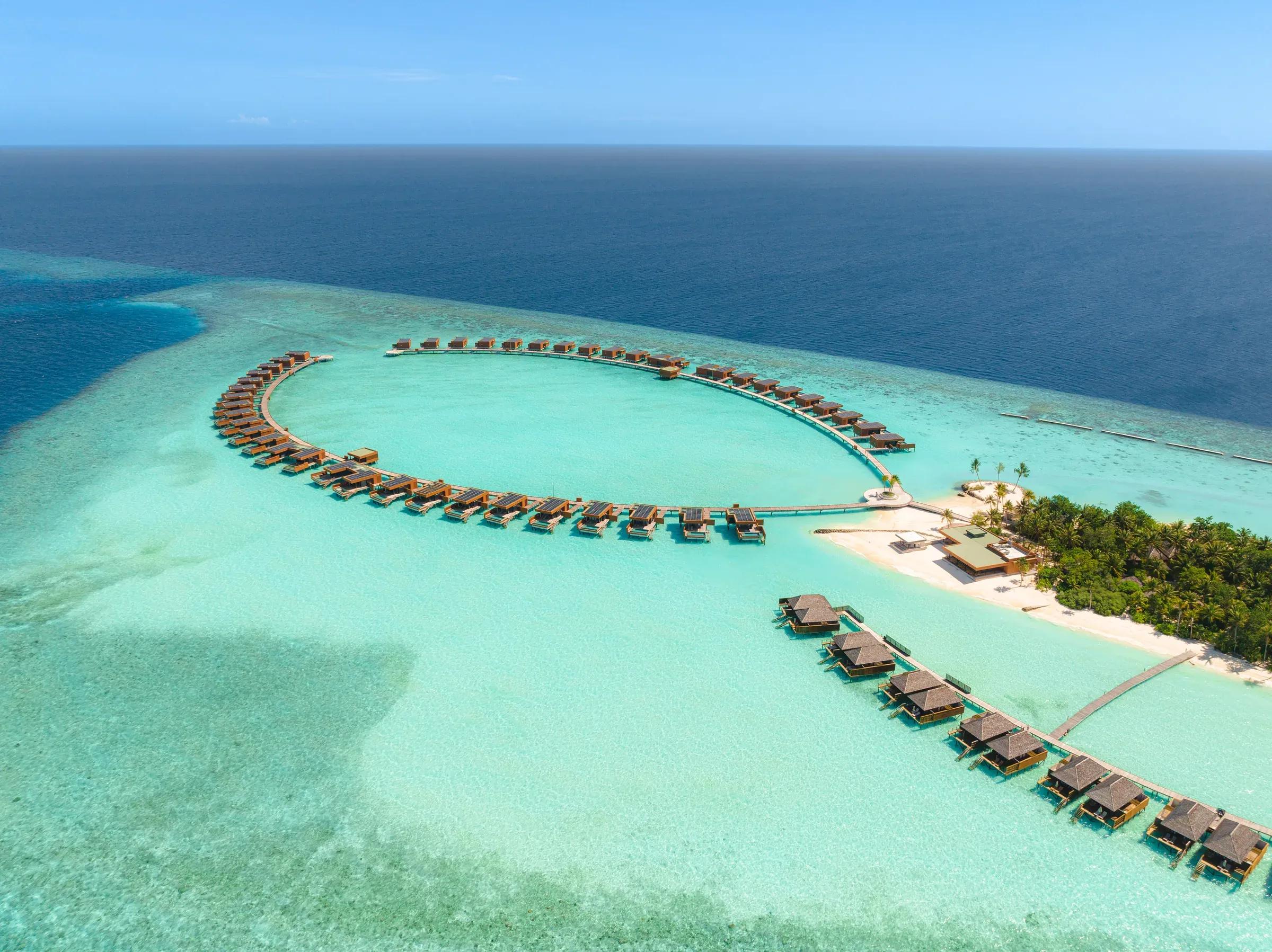 Vista aerea delle ville sull'acqua e della laguna turchese al Veligandu Island Resort & Spa.