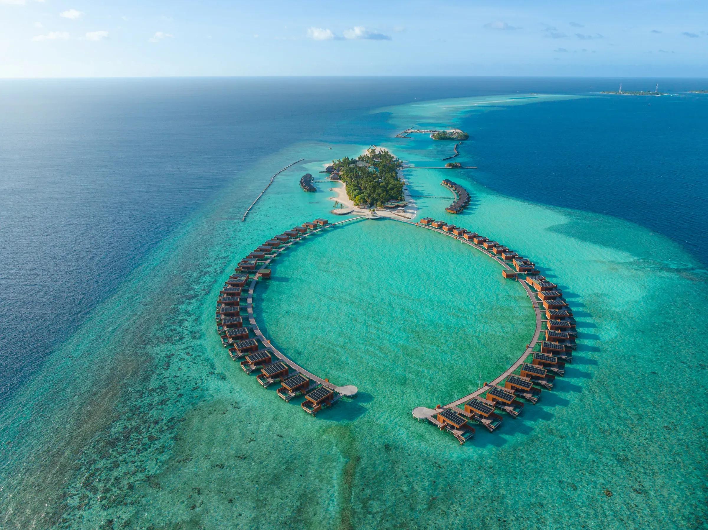Vista aerea dell'isola e ville sull'acqua disposte a semicerchio al Veligandu Island Resort & Spa.