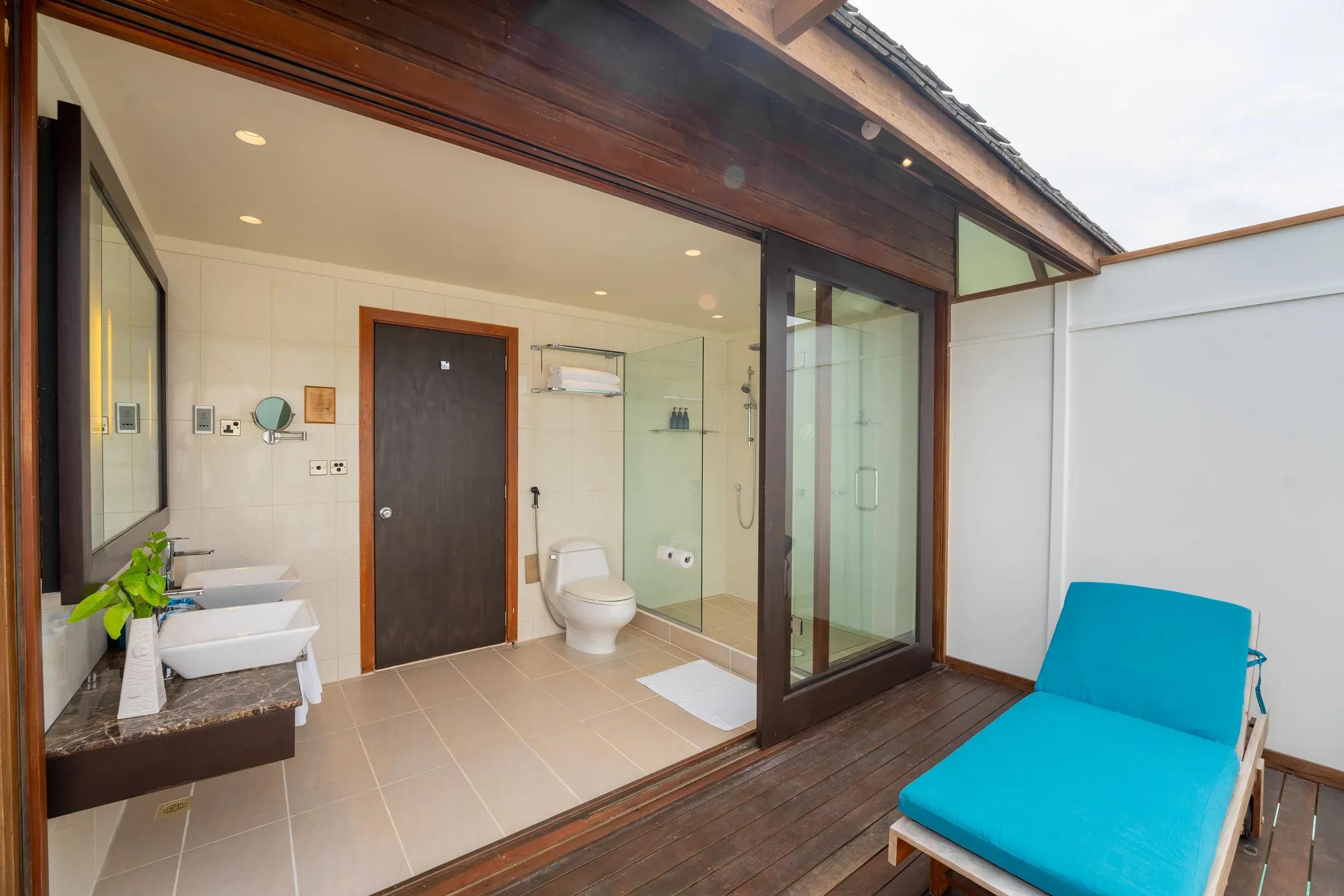 Vista del bagno e terrazza con lettino della Ocean Jacuzzi Villa al Veligandu Island Resort & Spa.