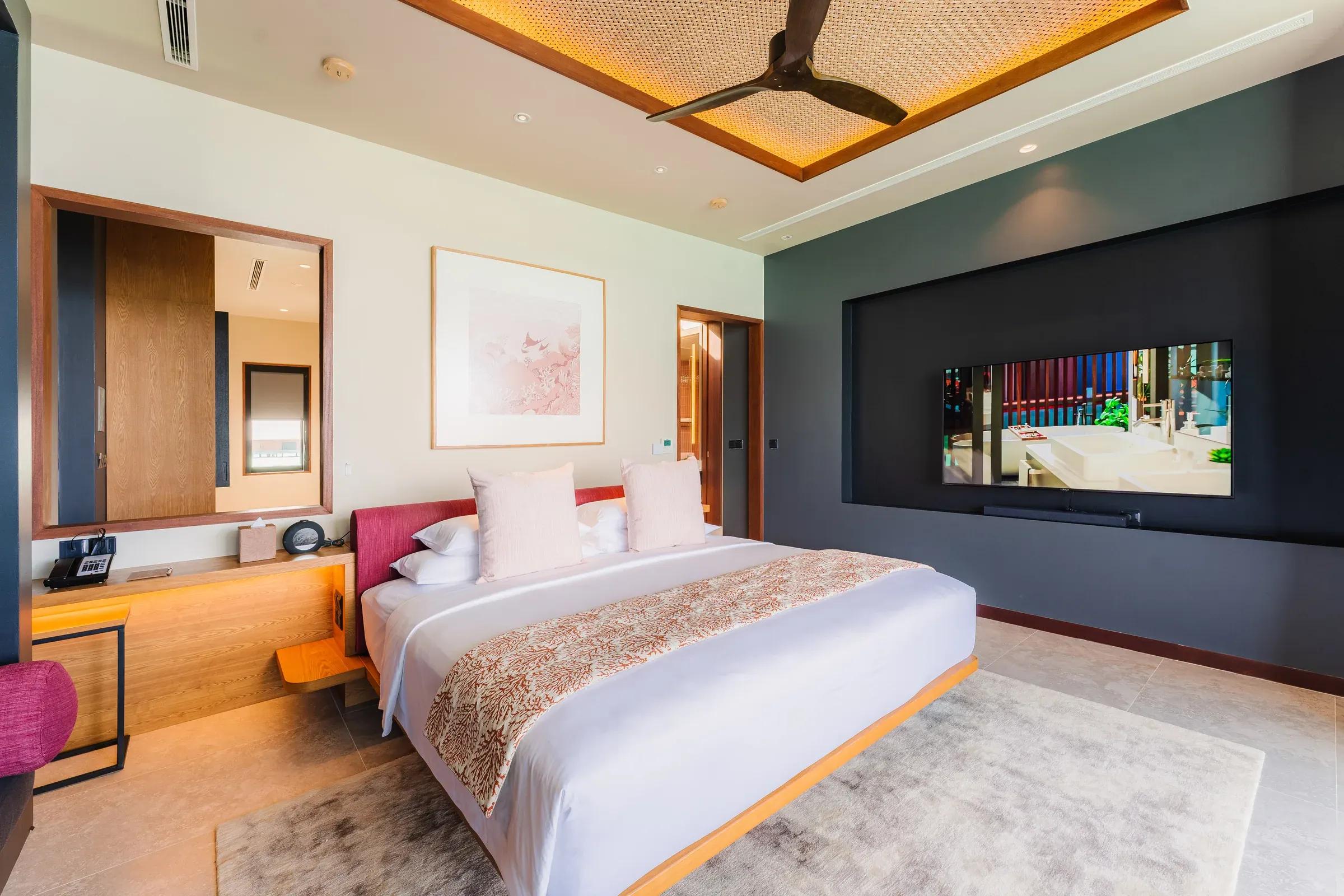 Camera da letto con letto matrimoniale e televisione nella Ocean Pool Villa 2 Bedroom del Veligandu Island Resort & Spa