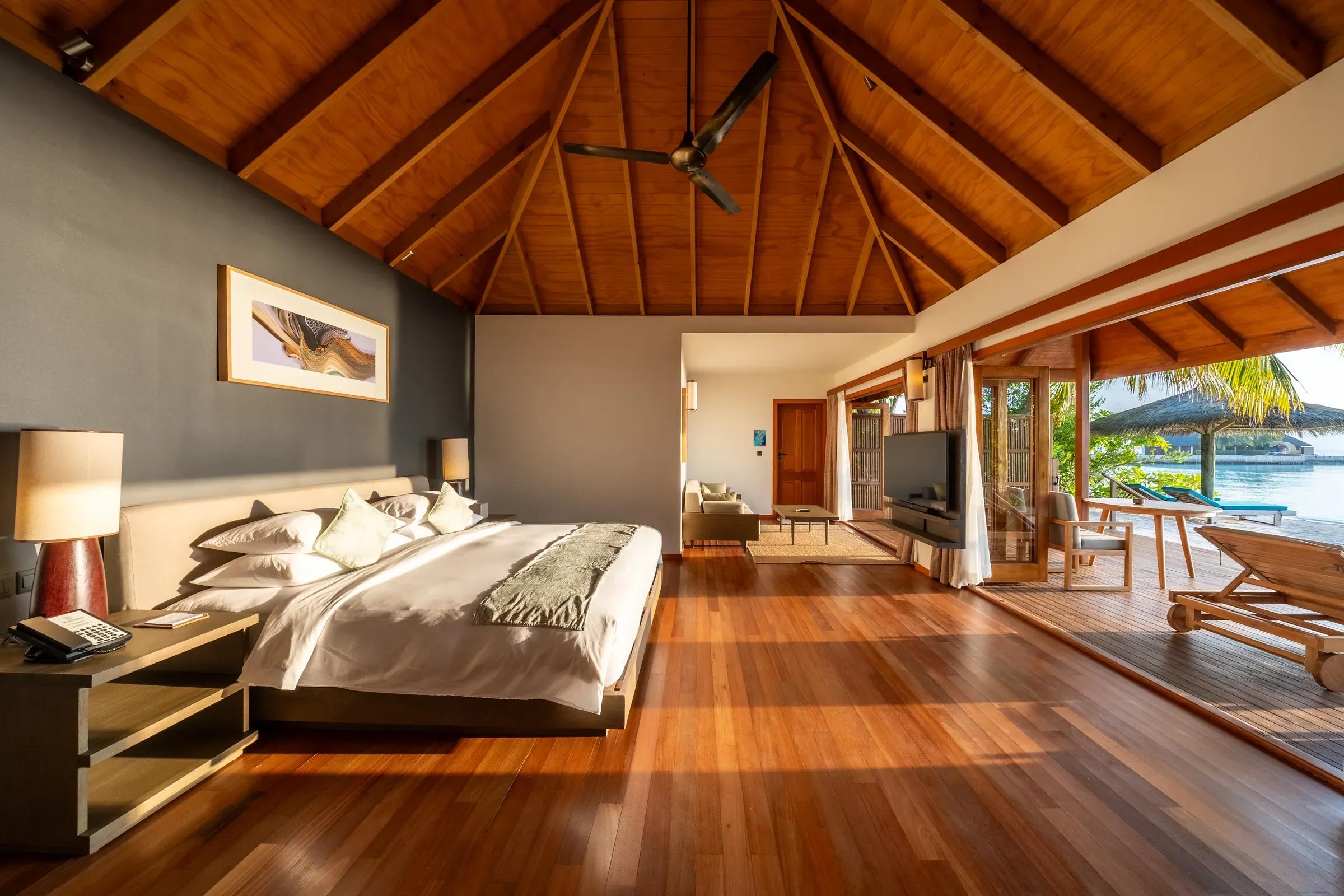 Interno della Sunset Jacuzzi Beach Villa con letto matrimoniale e terrazza vista mare al Veligandu Island Resort & Spa.