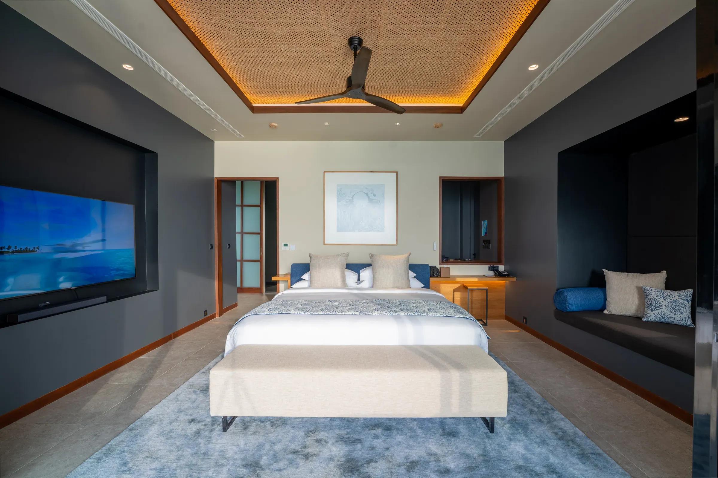 Interno della Sunset Ocean Pool Villa - 2 Bedroom con letto matrimoniale e TV a schermo piatto al Veligandu Island Resort & Spa.