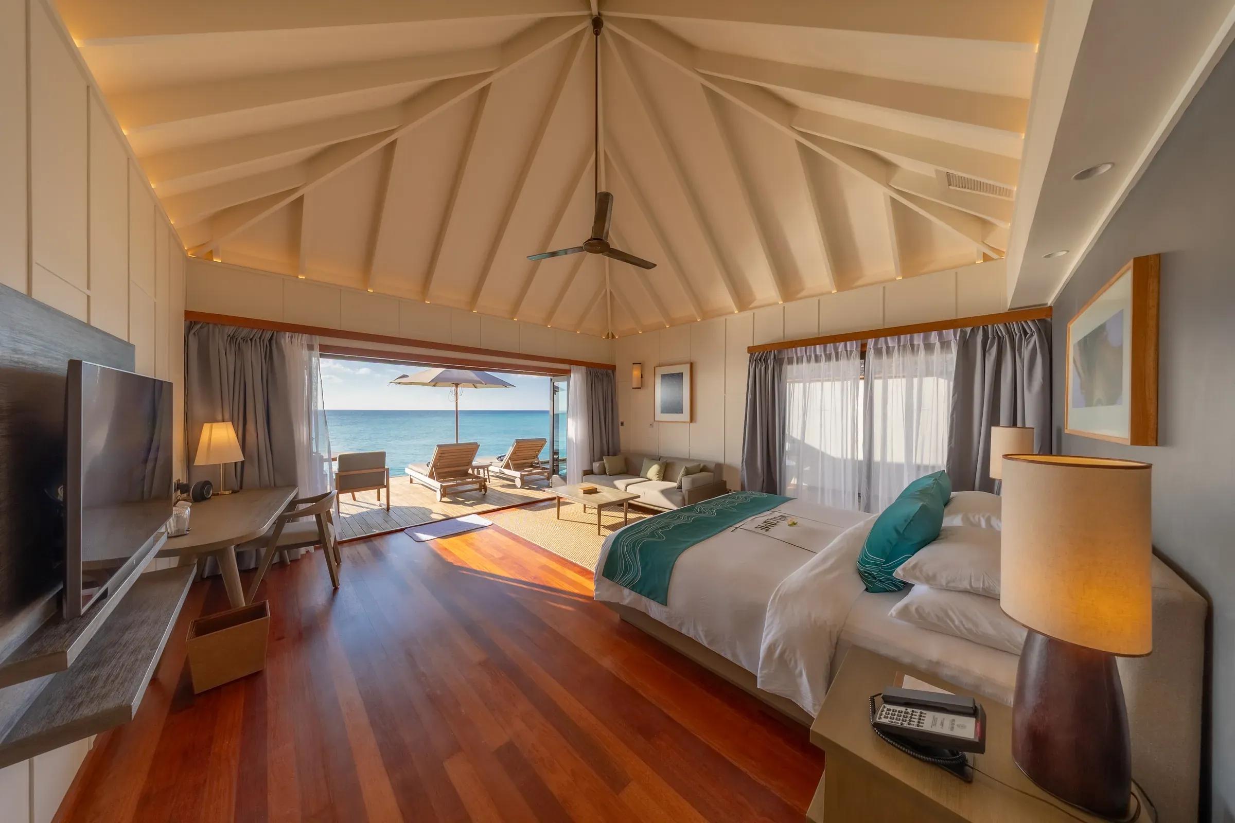 Interno della Sunset Ocean Villa con letto e terrazza vista mare al Veligandu Island Resort & Spa