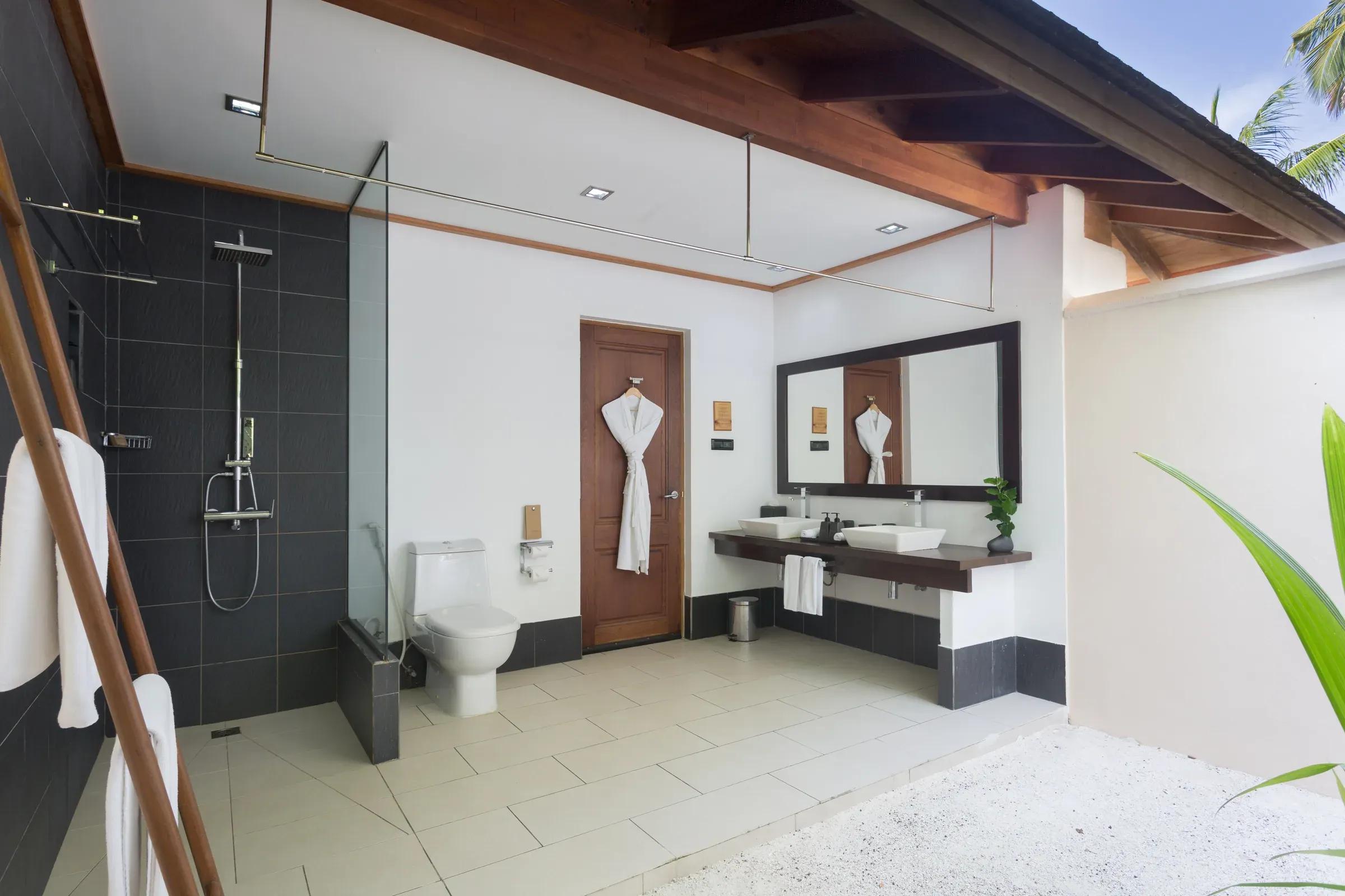 Bagno della Adjacent Beachfront Villa con doccia a pioggia e doppio lavandino al Vilamendhoo Maldives.