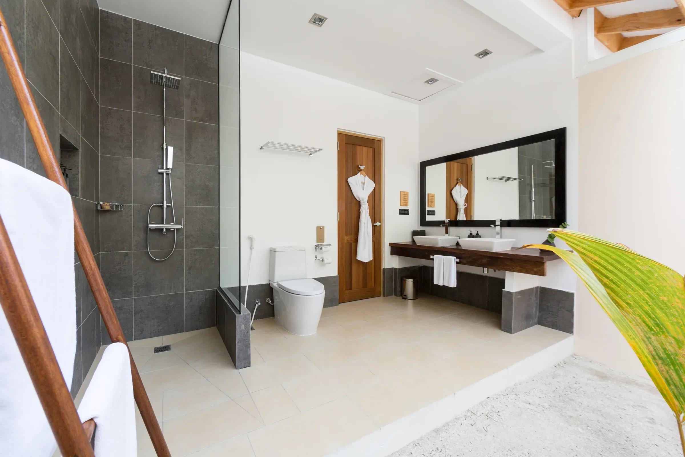Bagno moderno con doccia e doppio lavabo della Garden Room al Vilamendhoo Island Resort & Spa