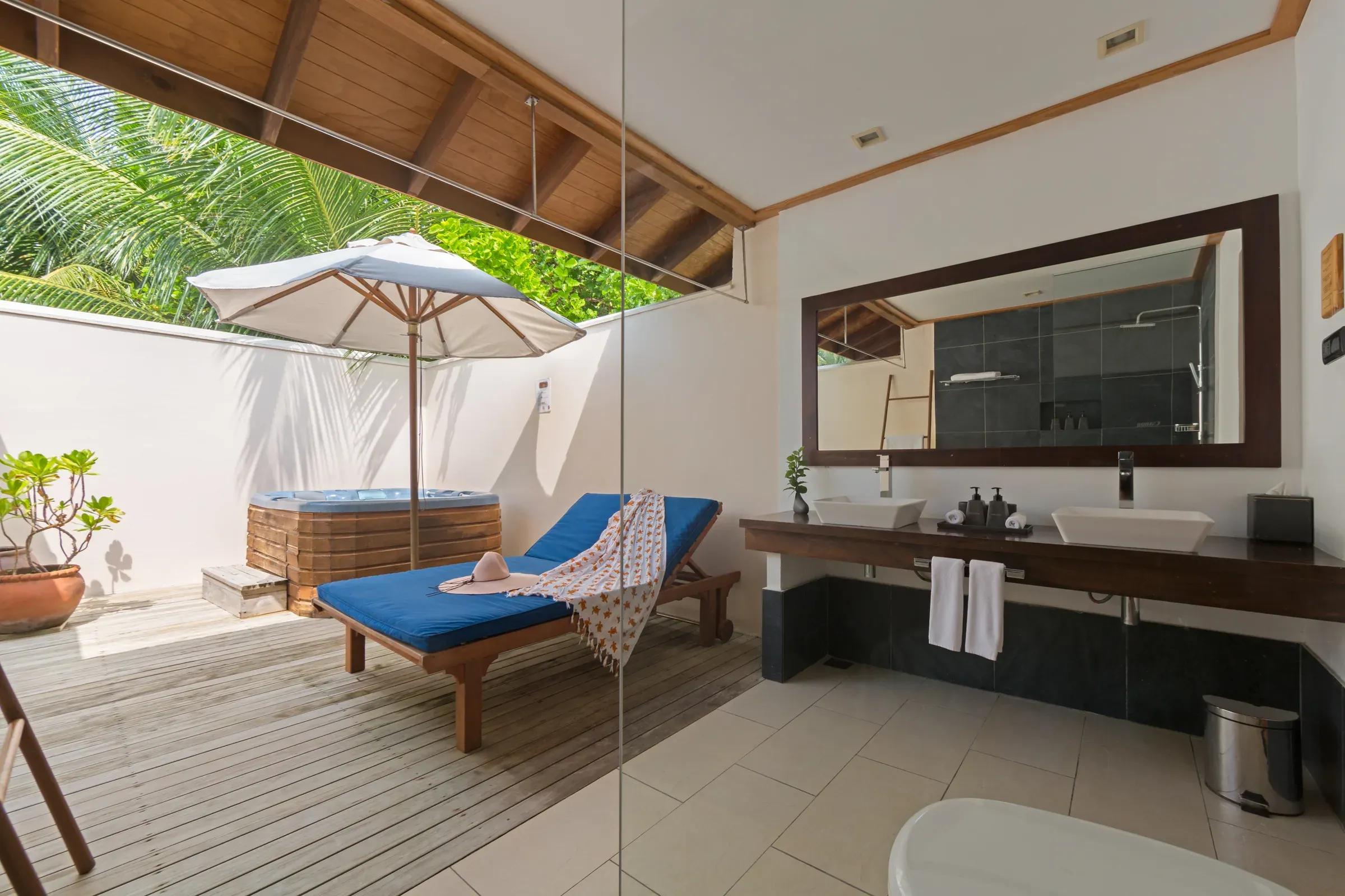 Esterno della Romantic Beachfront Villa con jacuzzi e lettino al Vilamendhoo Maldives