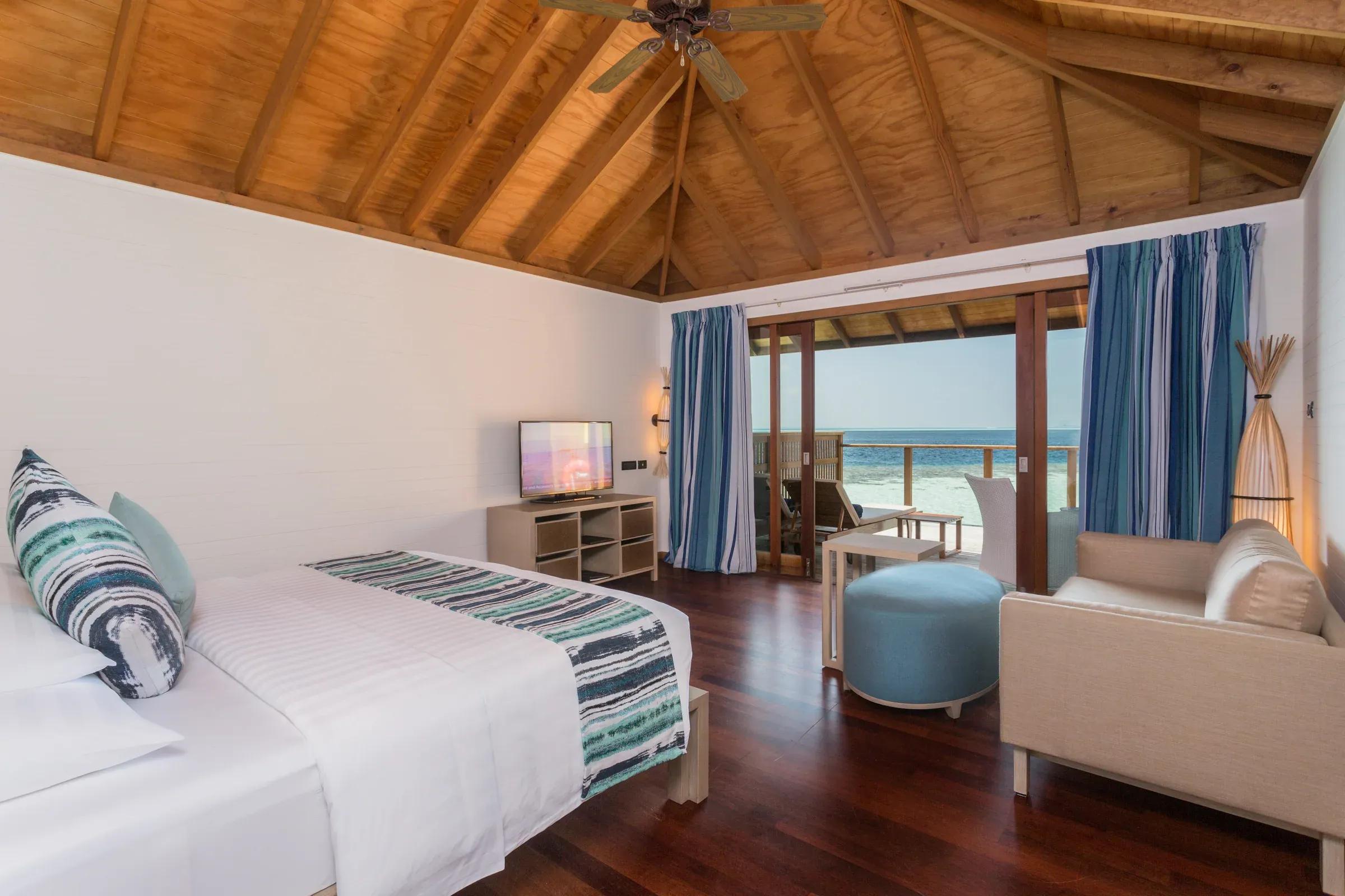 Interno della Romantic Ocean Villa con letto matrimoniale e vista sull'oceano dal Vilamendhoo Maldives.