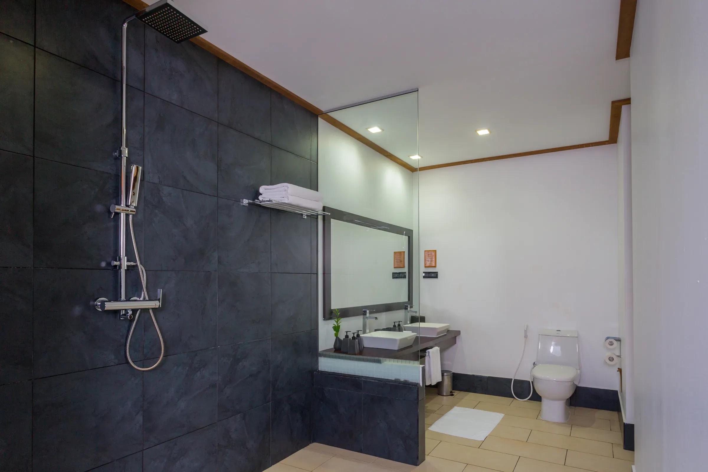 Bagno della Romantic Ocean Villa con cabina doccia e doppio lavabo al Vilamendhoo Maldives.