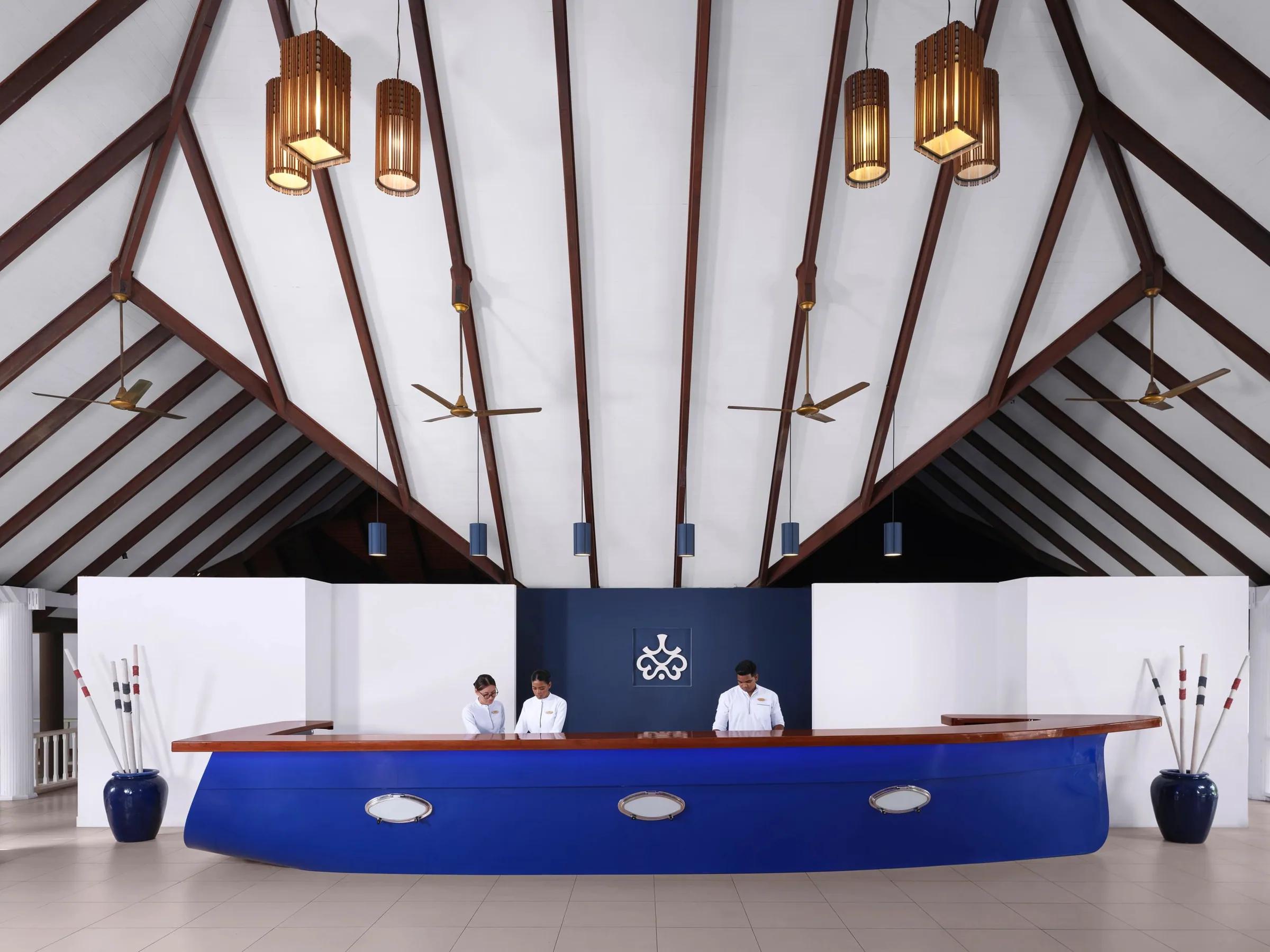 Reception con bancone blu e travi in legno a soffitto al Villa Nautica, Paradise Island.