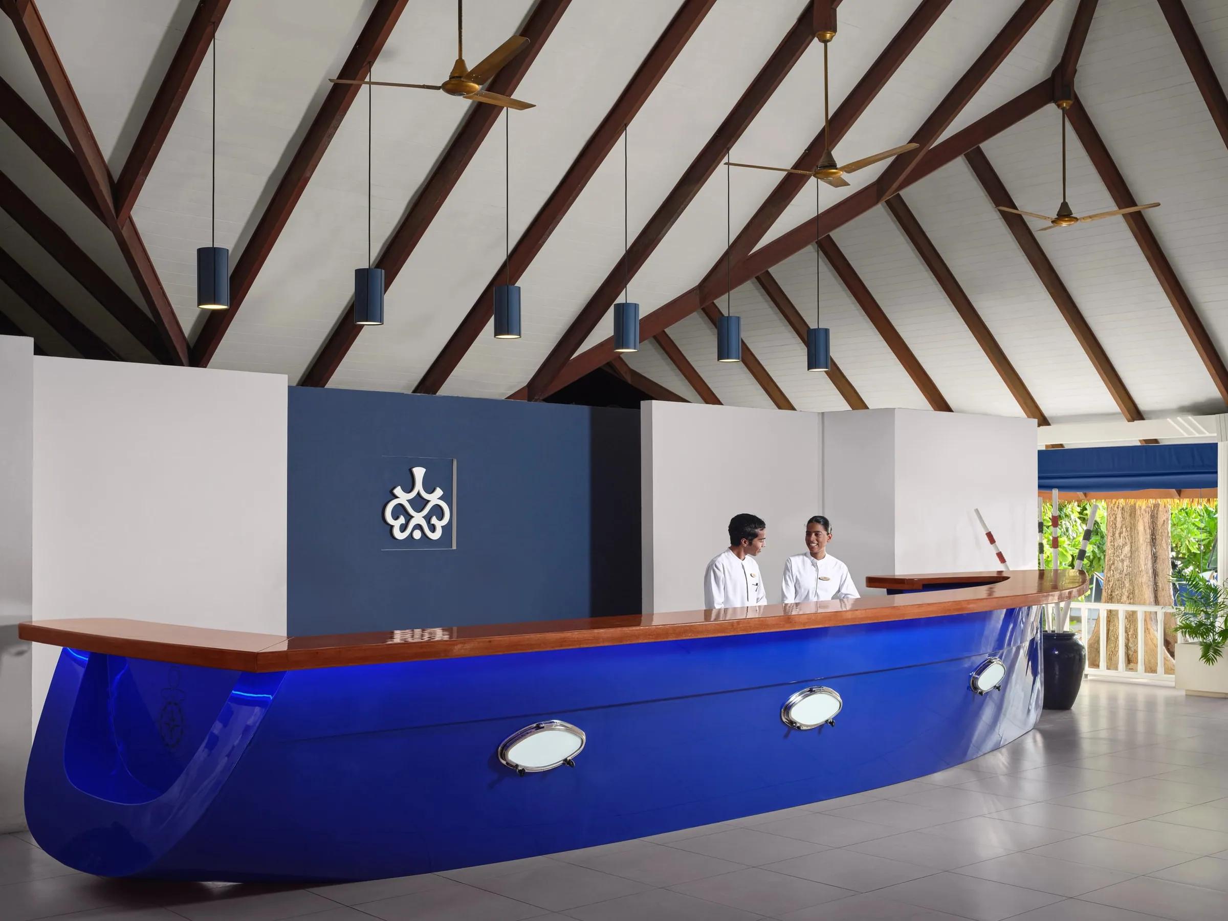 Reception con bancone blu e soffitto con travi al Villa Nautica, Paradise Island.