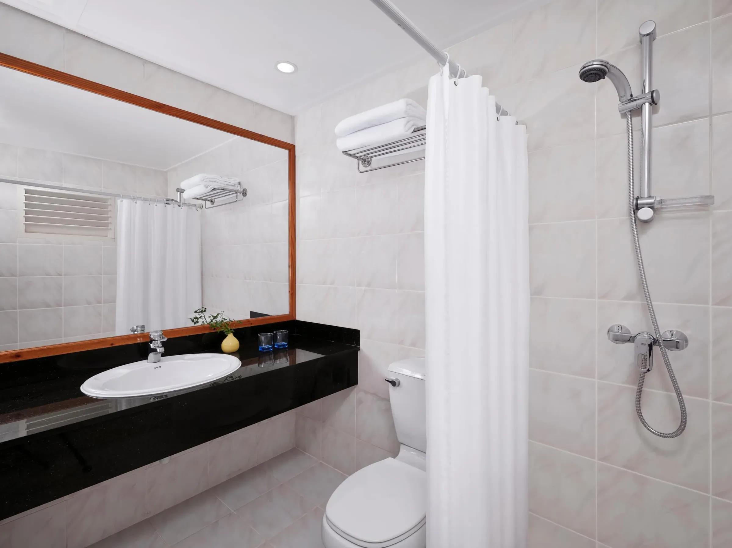 Bagno privato moderno e luminoso della Beach Villa, dotato di una spaziosa doccia, un elegante lavabo con top scuro e comfort essenziali per un soggiorno rilassante al Villa Park Sun Island Resort & Spa.
