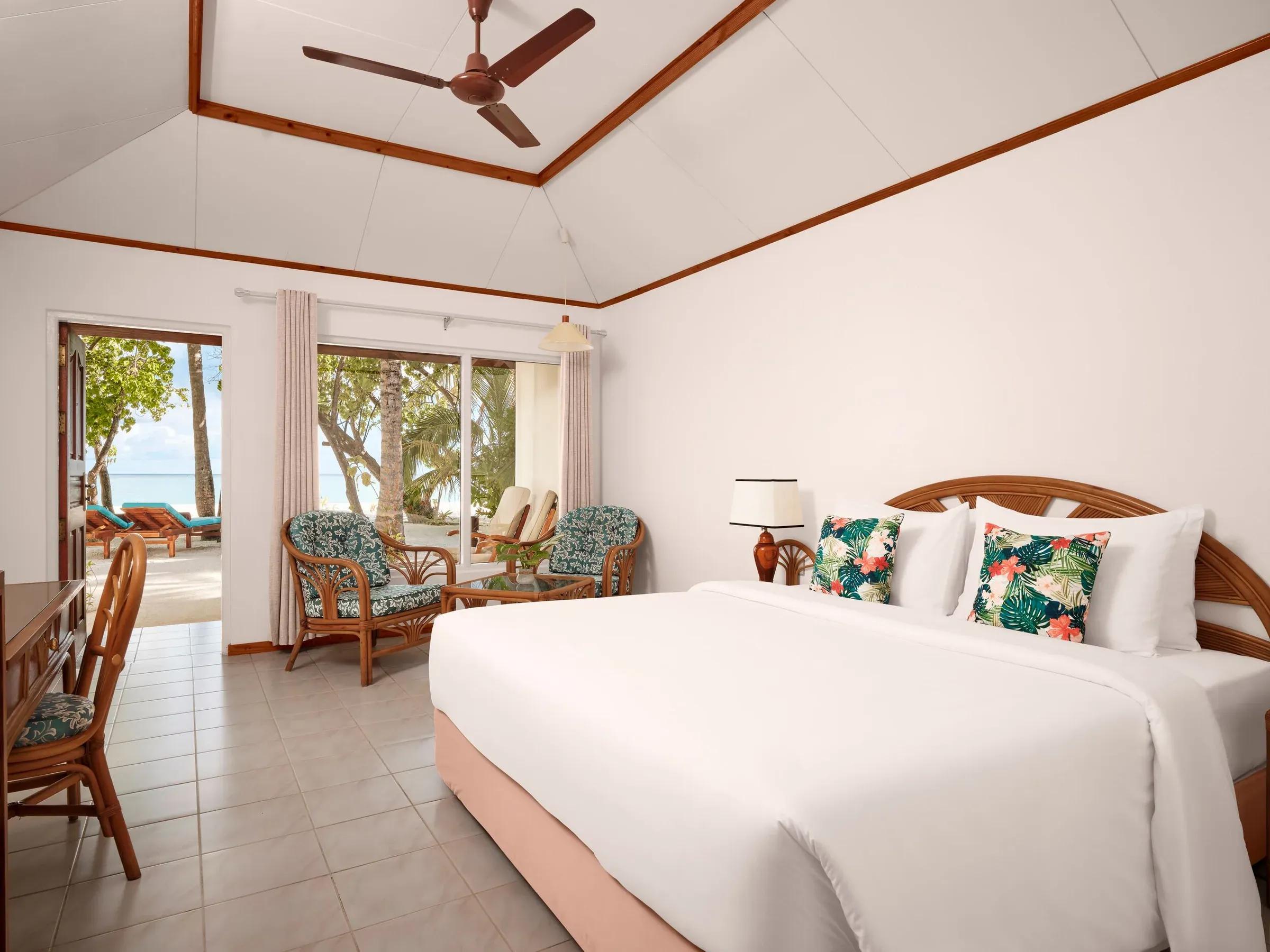 Luminosa camera da letto della Beach Villa con letto king-size, arredi in stile tropicale e accesso diretto alla spiaggia con vista sull'oceano cristallino del Villa Park Sun Island Resort & Spa.