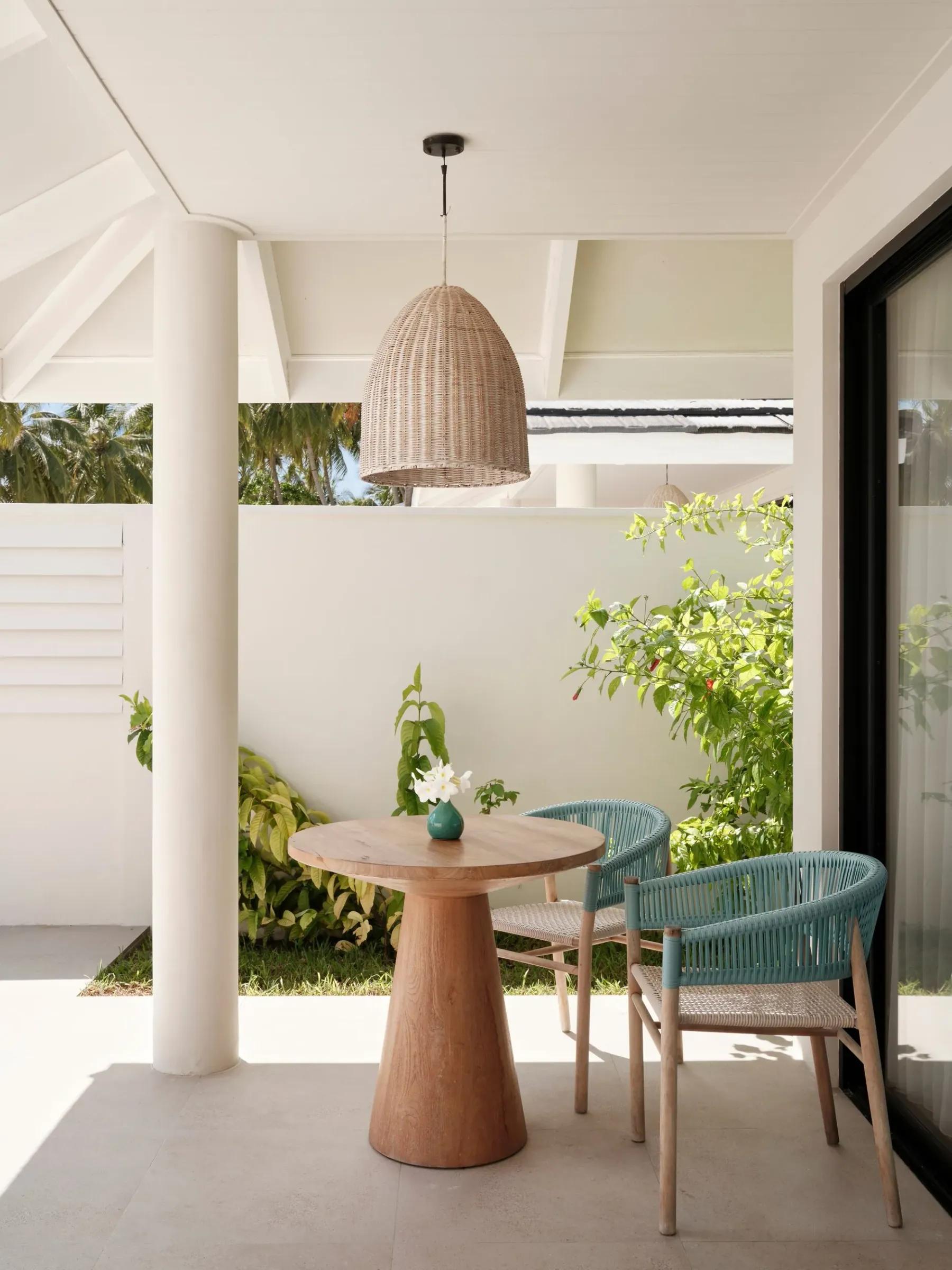 Terrazza privata della Beach Villa with Whirlpool al Villa Park Sun Island Resort & Spa, con tavolo in legno e sedie eleganti immerse in un giardino lussureggiante.