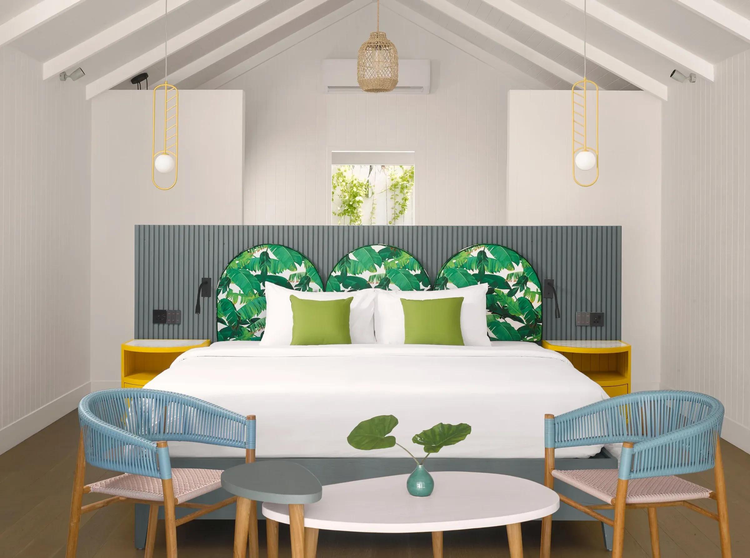 Interno della Deluxe Beach Pool Villa con letto matrimoniale e poltrone al Villa Park Sun Island Resort & Spa.