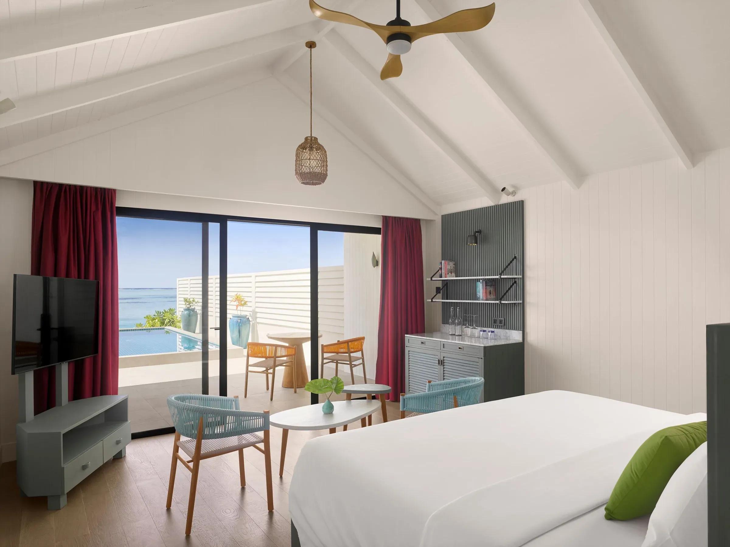 Interno luminoso della Deluxe Beach Pool Villa con letto king-size, arredi moderni e accesso alla terrazza privata con piscina a sfioro e vista sull'Oceano Indiano al Villa Park Sun Island Resort & Spa.