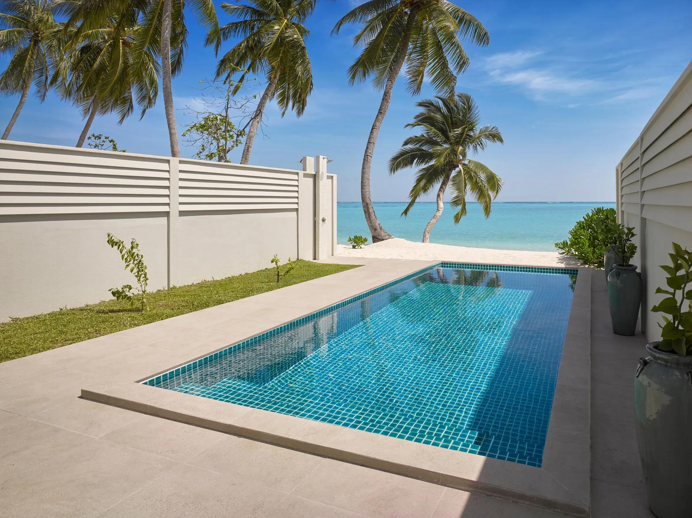 Piscina privata della Deluxe Beach Pool Villa con vista su palme e spiaggia al Villa Park Sun Island Resort & Spa.