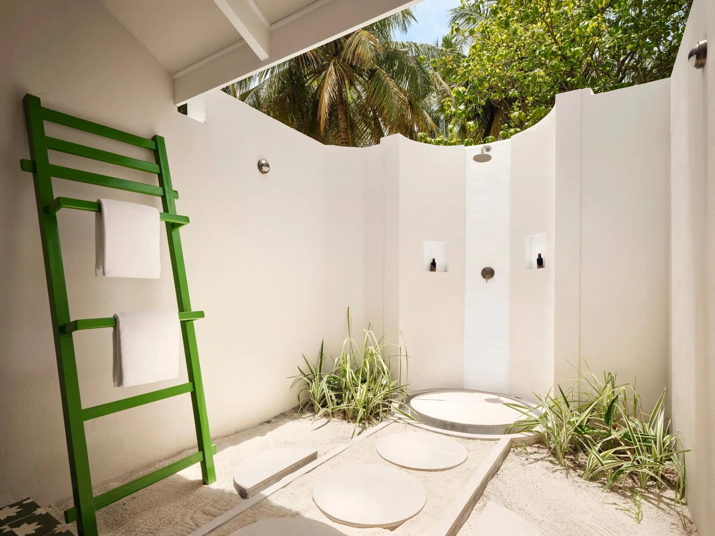 Elegante bagno esterno nella Lagoon Beach Villa del Villa Park Sun Island Resort & Spa, con design minimalista e doccia a cielo aperto, circondato da rigogliosa vegetazione tropicale.