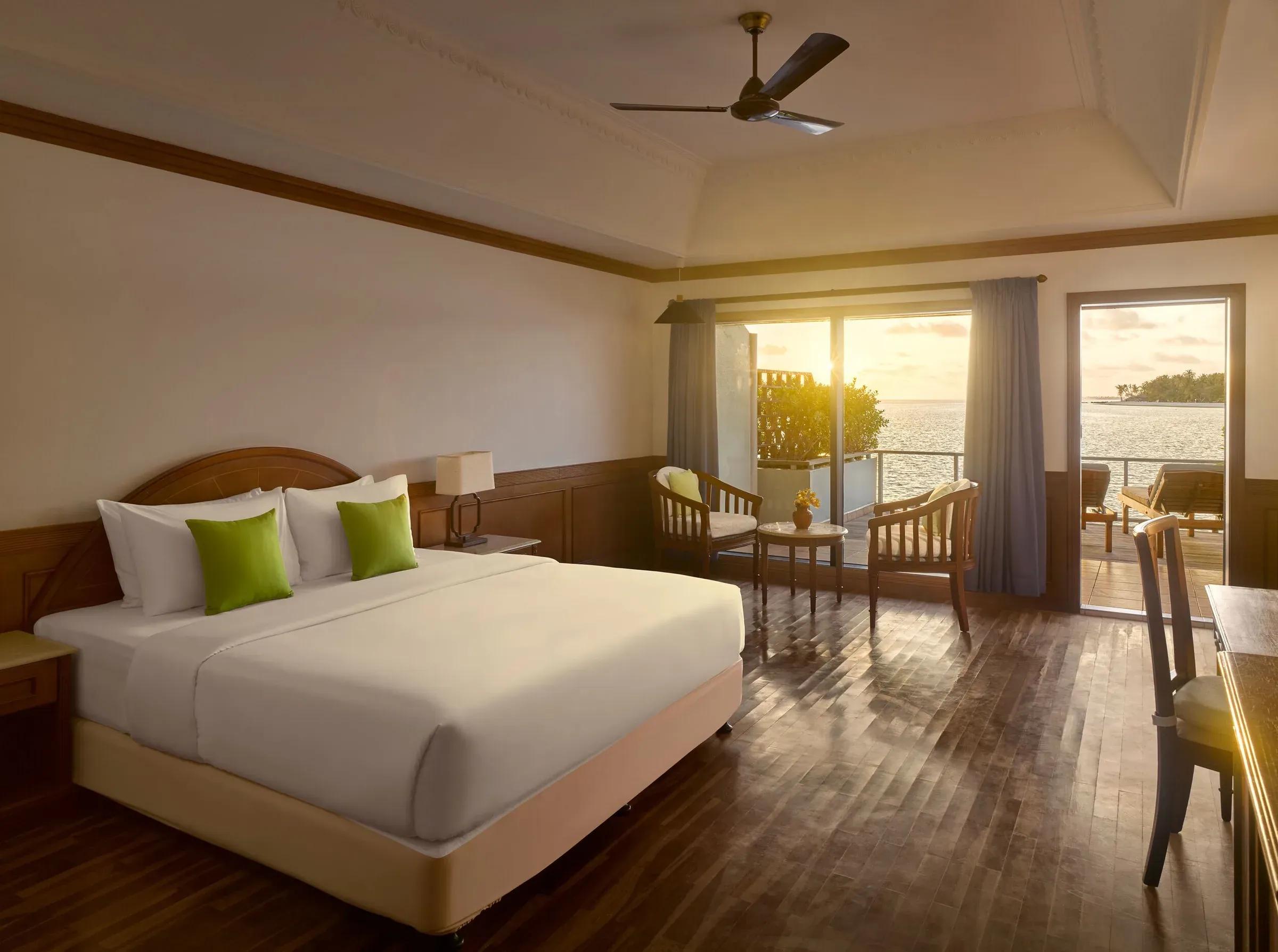 Camera della Sunset Water Villa con letto matrimoniale e terrazza sul mare al Villa Park Sun Island Resort & Spa.
