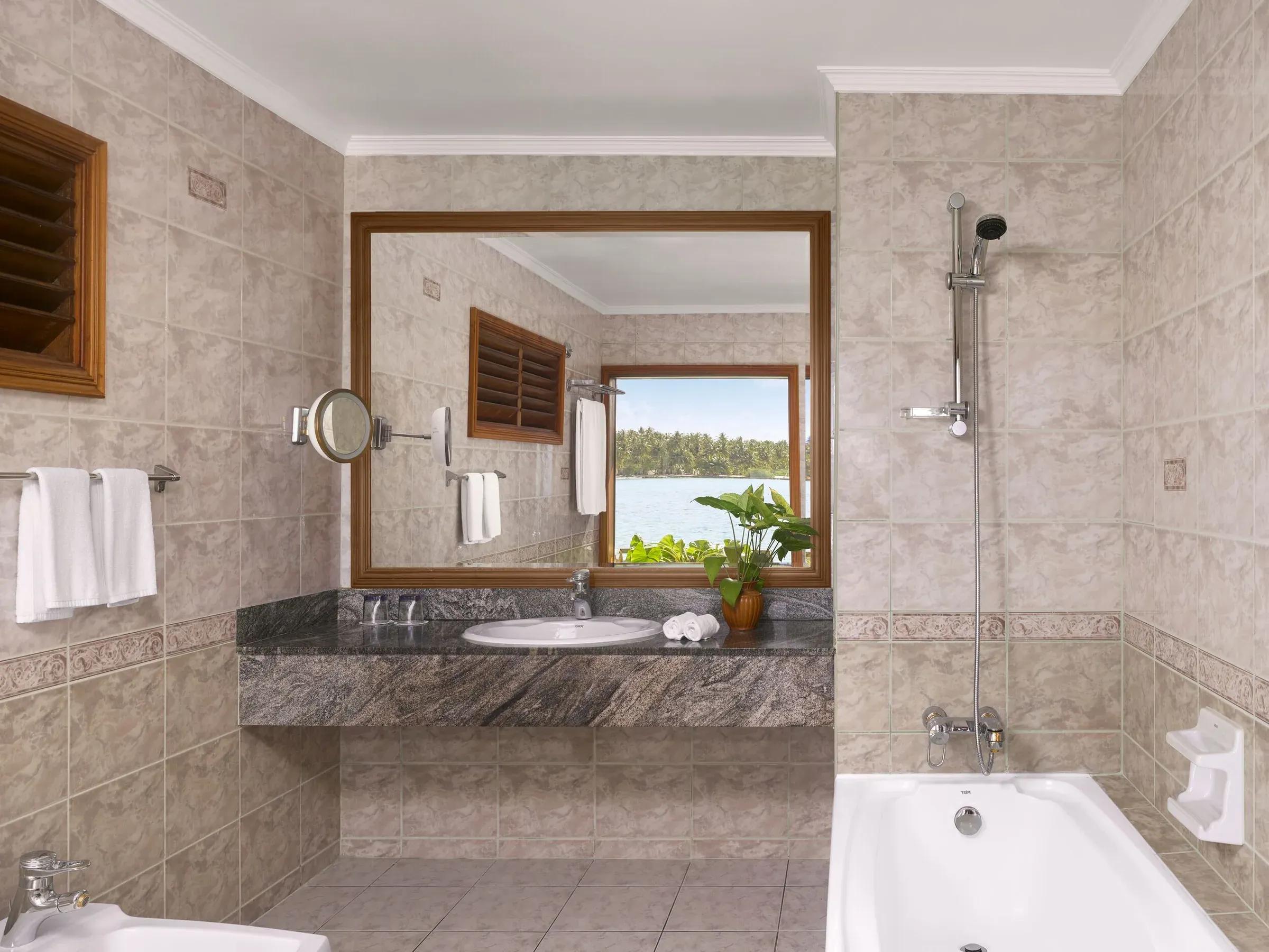 Bagno della Water Villa con vasca e vista mare al Villa Park Sun Island Resort & Spa