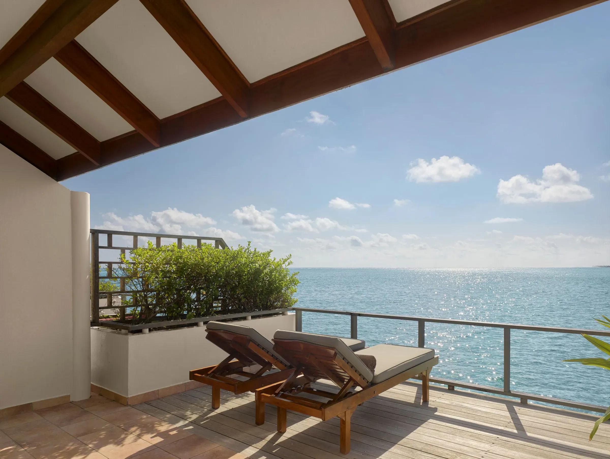Terrazza della Water Villa con lettini in legno e vista mare al Villa Park Sun Island Resort & Spa.